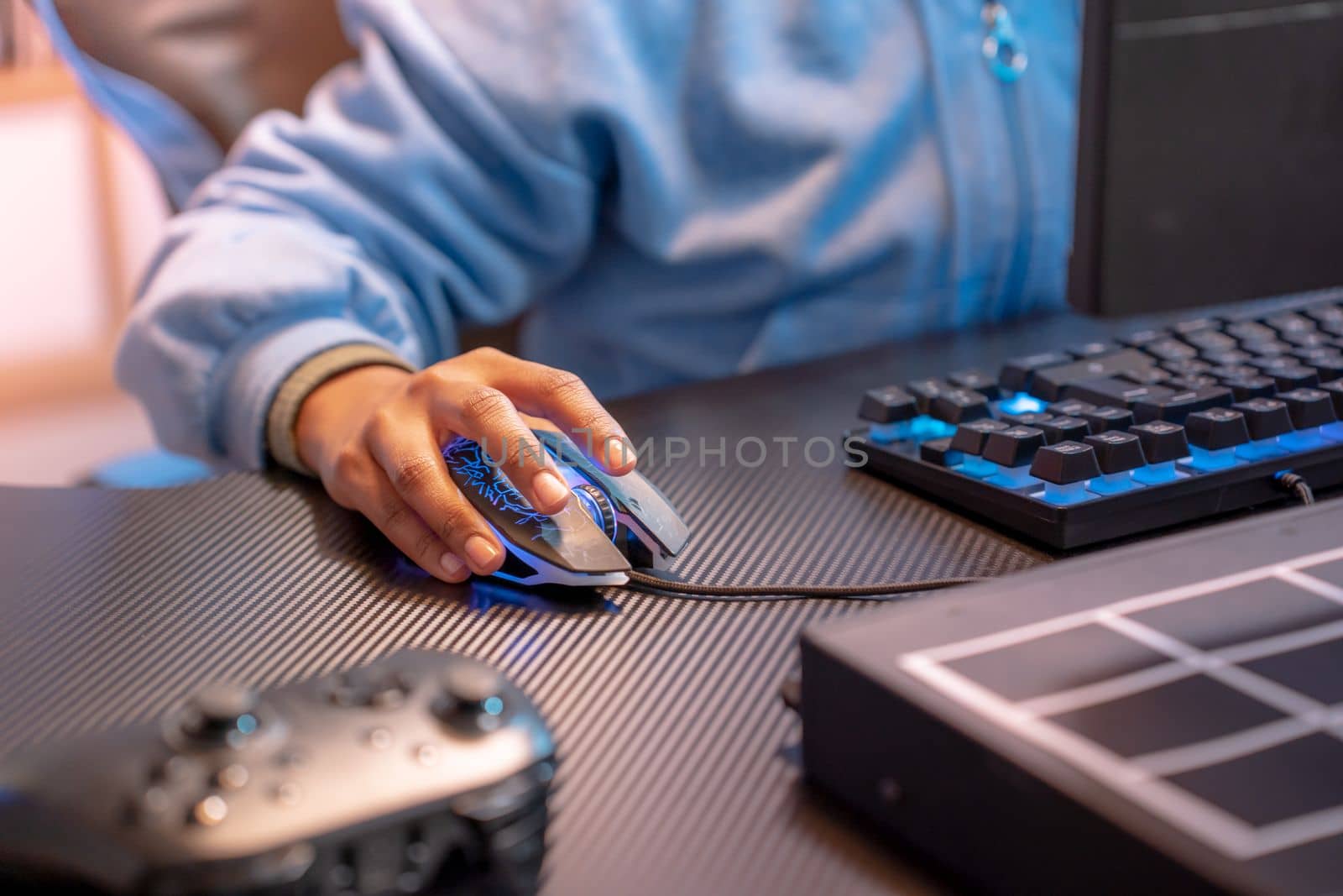 Closeup of unrecognizable hispanic woman hand clicking computer mouse game streaming online. High quality photo