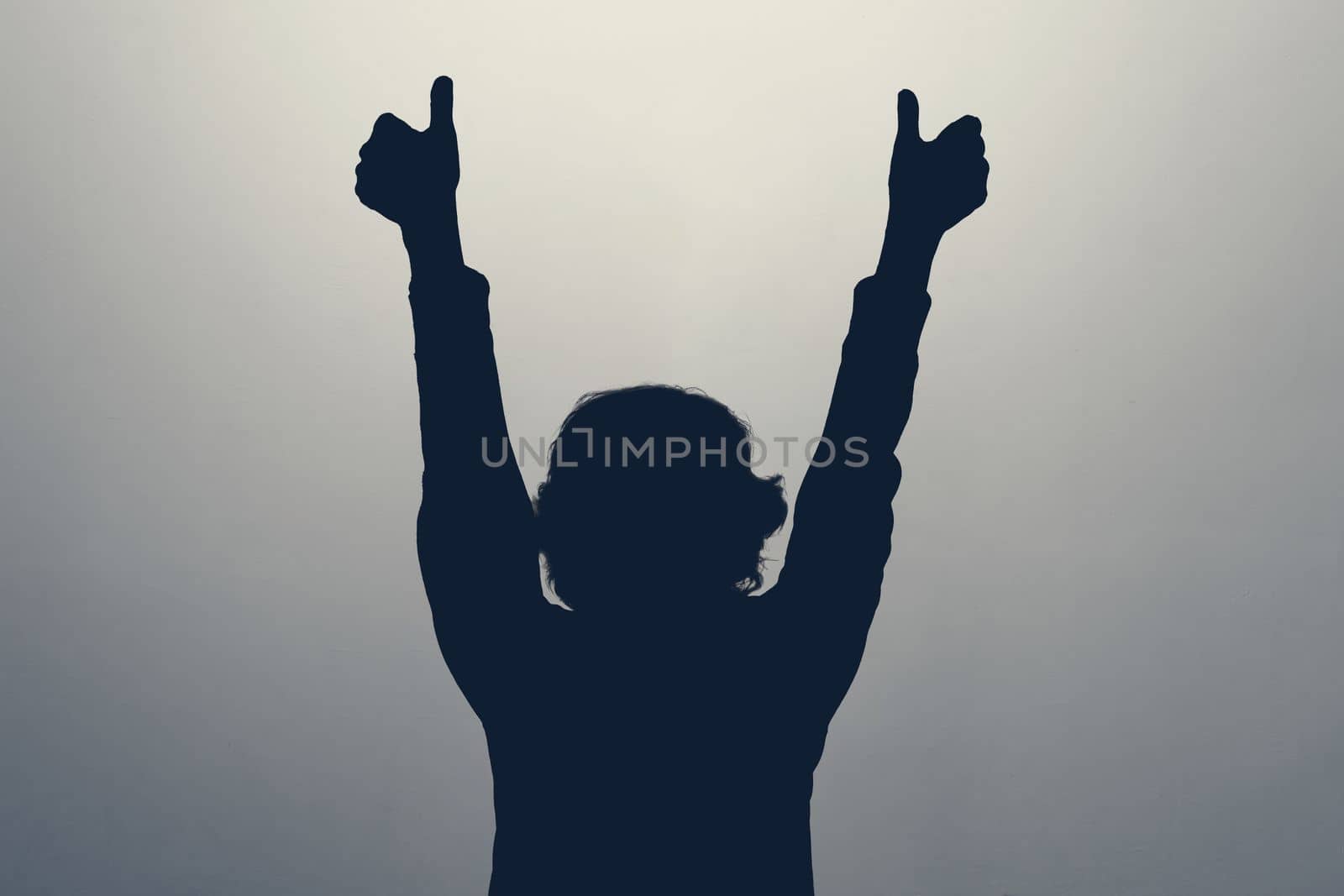 Unknown female person silhouette in studio showing thumb up approving your choice