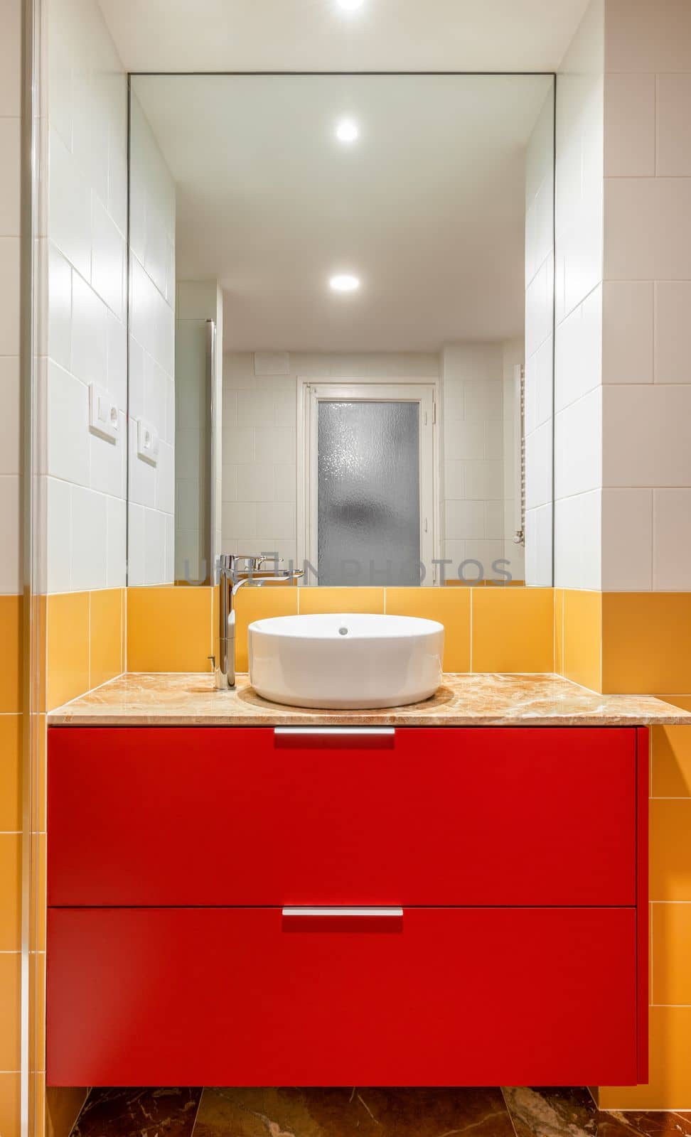 New empty bathroom with yellow tiles and round sink on red furniture by apavlin