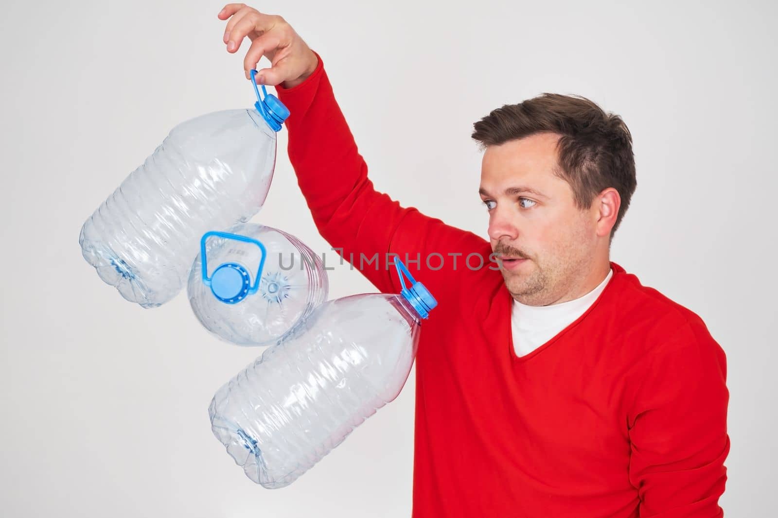 Caucasian man holding empty plastic bottles for water. Pure water crisis concept.