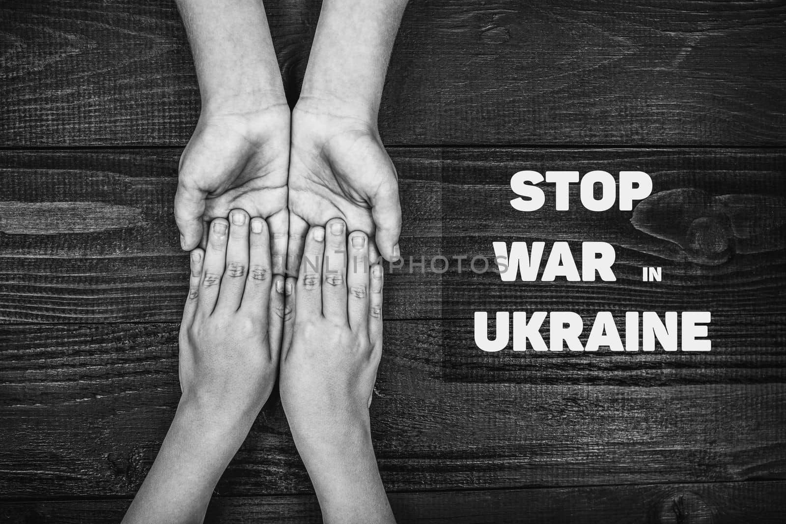 childrens hands holding each other with words stop war in ukraine black and white color. concept needs help and support, truth will win
