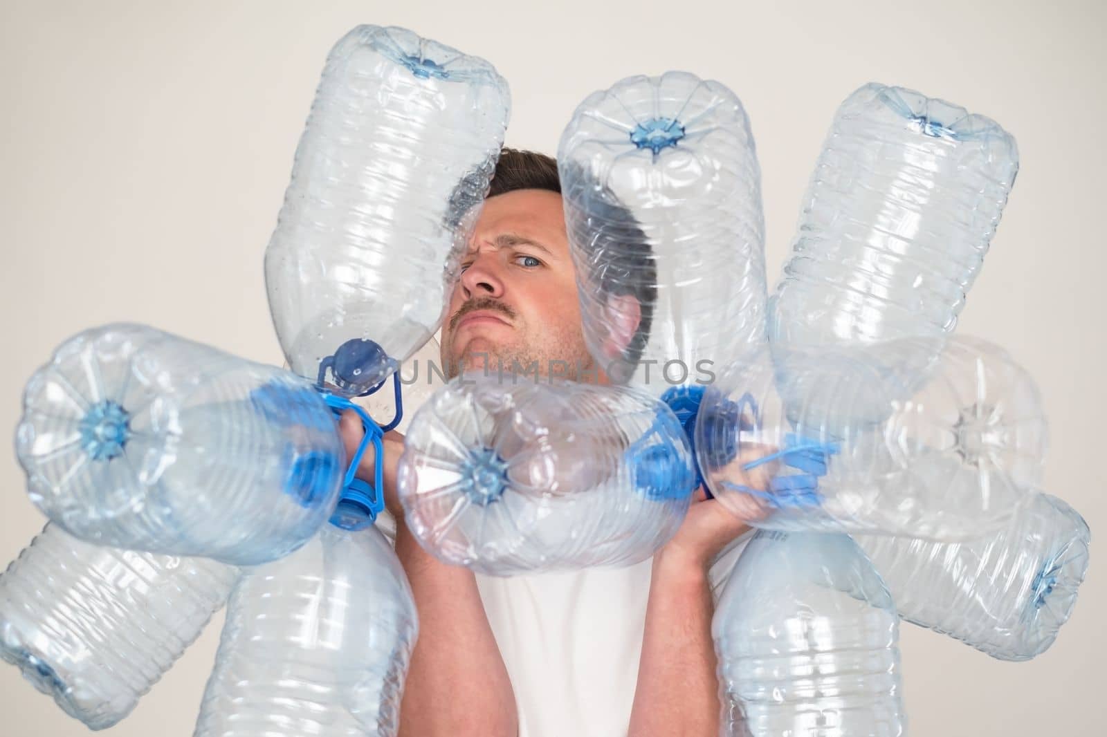 Caucasian man holding empty plastic bottles for water. Pure water crisis concept.