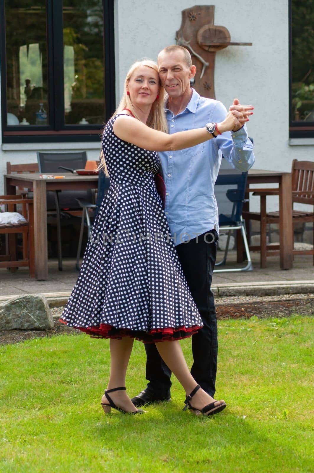 beautiful young couple of newlyweds dancing tango on the lawn in the garden by KaterinaDalemans