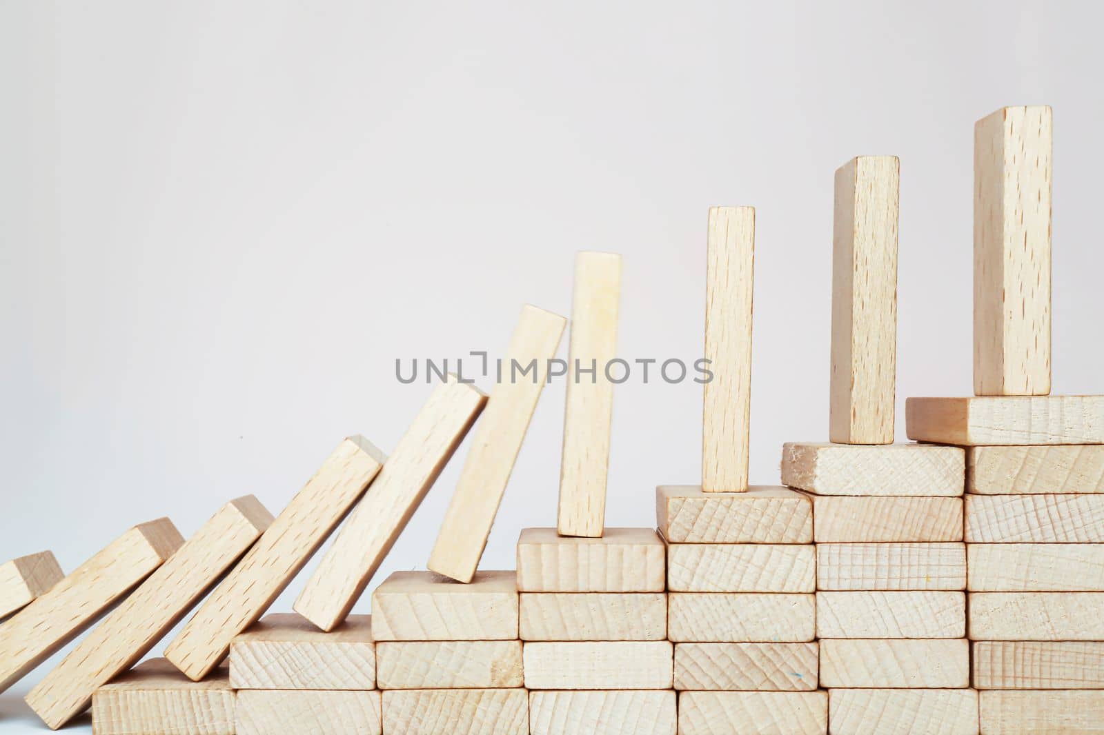 Dominoes. Domino effect climbing the stairs on a wooden staircase lined with steps. Business management ideas for sustainable growth and profitability.