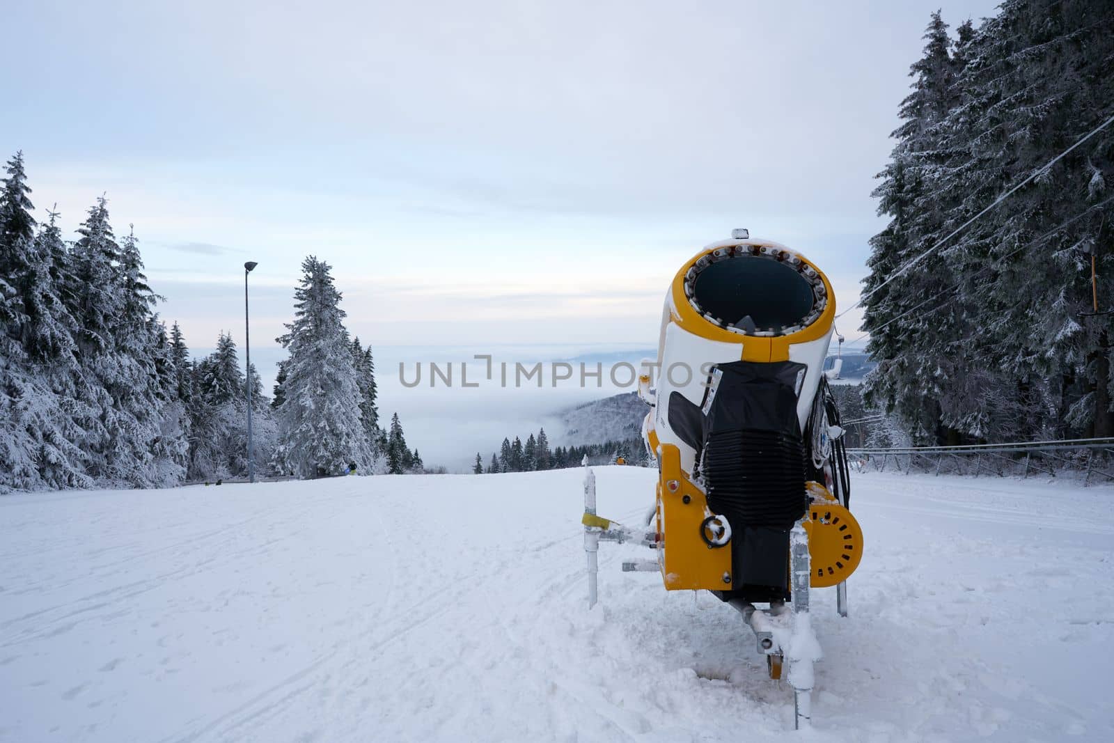 Yellow artificial snow cannon on Wasserkuppe ski resort in Rhoen Hesse Germany, on snowy mountain after fresh snow fall in 2022 december by Costin