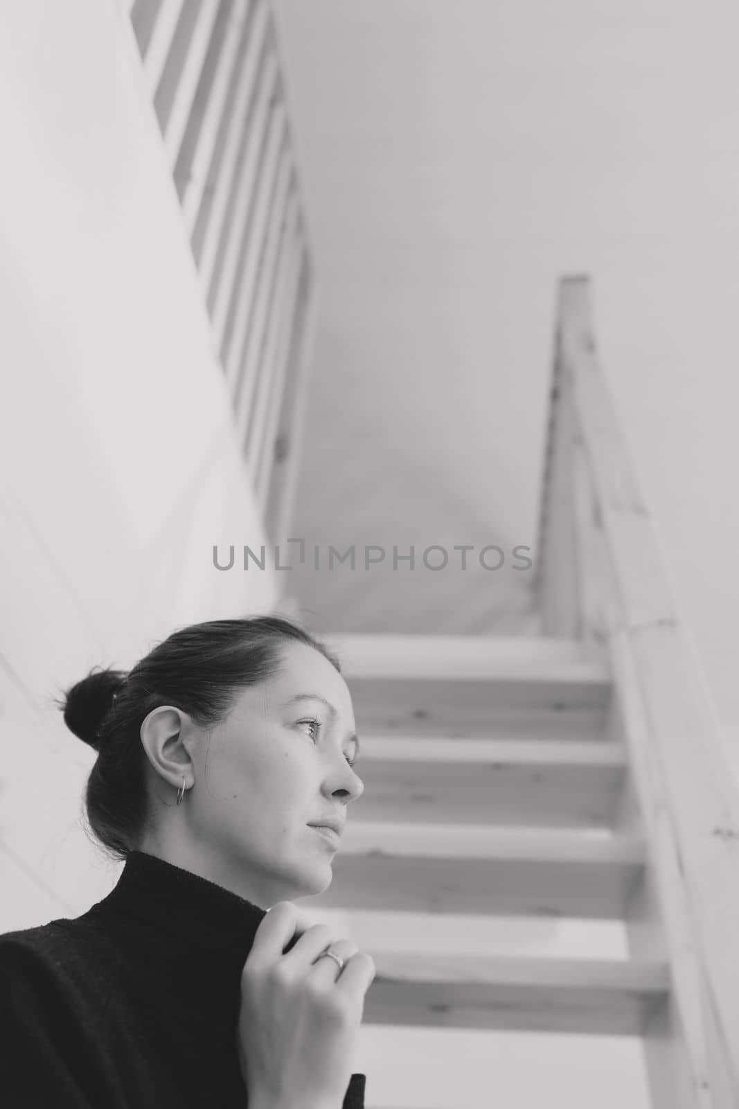 Young woman simple hairstyle against wooden stairs. Depression, loneliness and quarantine concept. Mental health, Self care, staying home.
