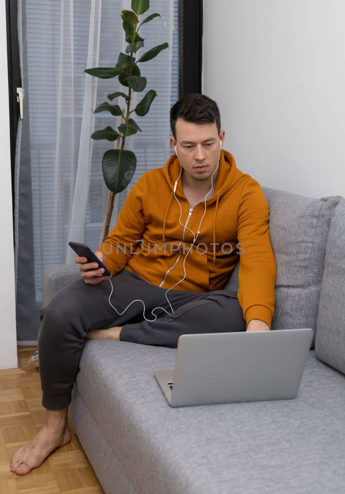 young man watching at laptop playing game by Chechotkin