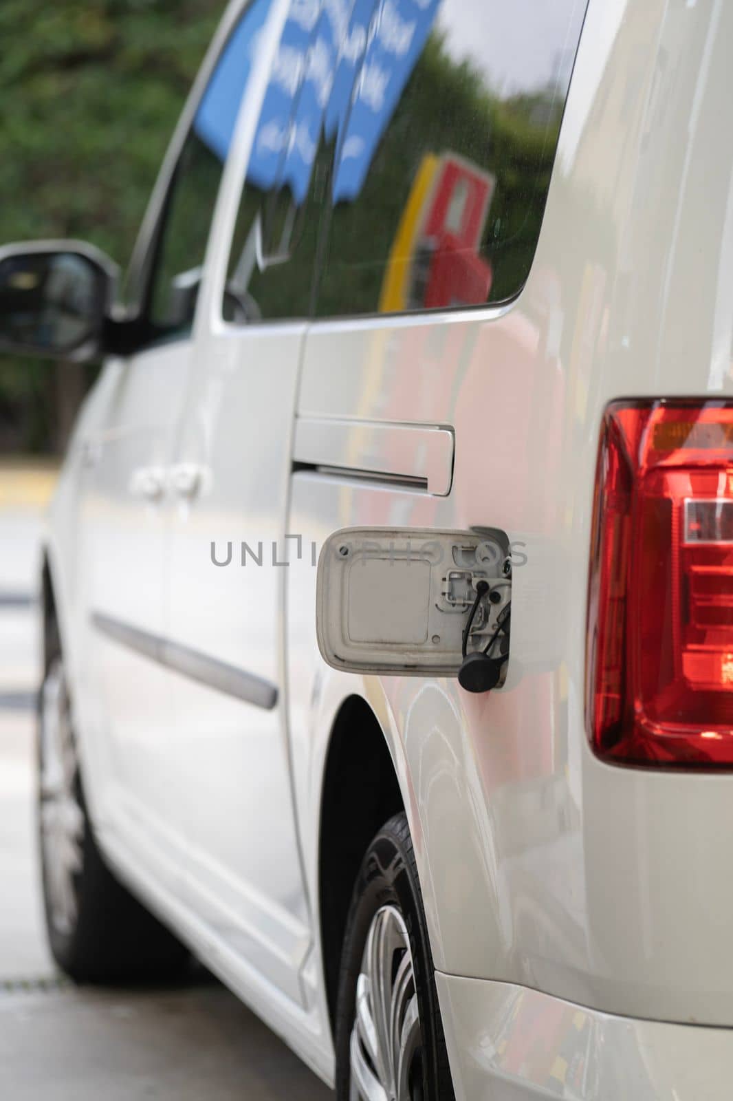 Vehicle with gas cap opened ready to refuel with gas or petrol at a gas station. by papatonic