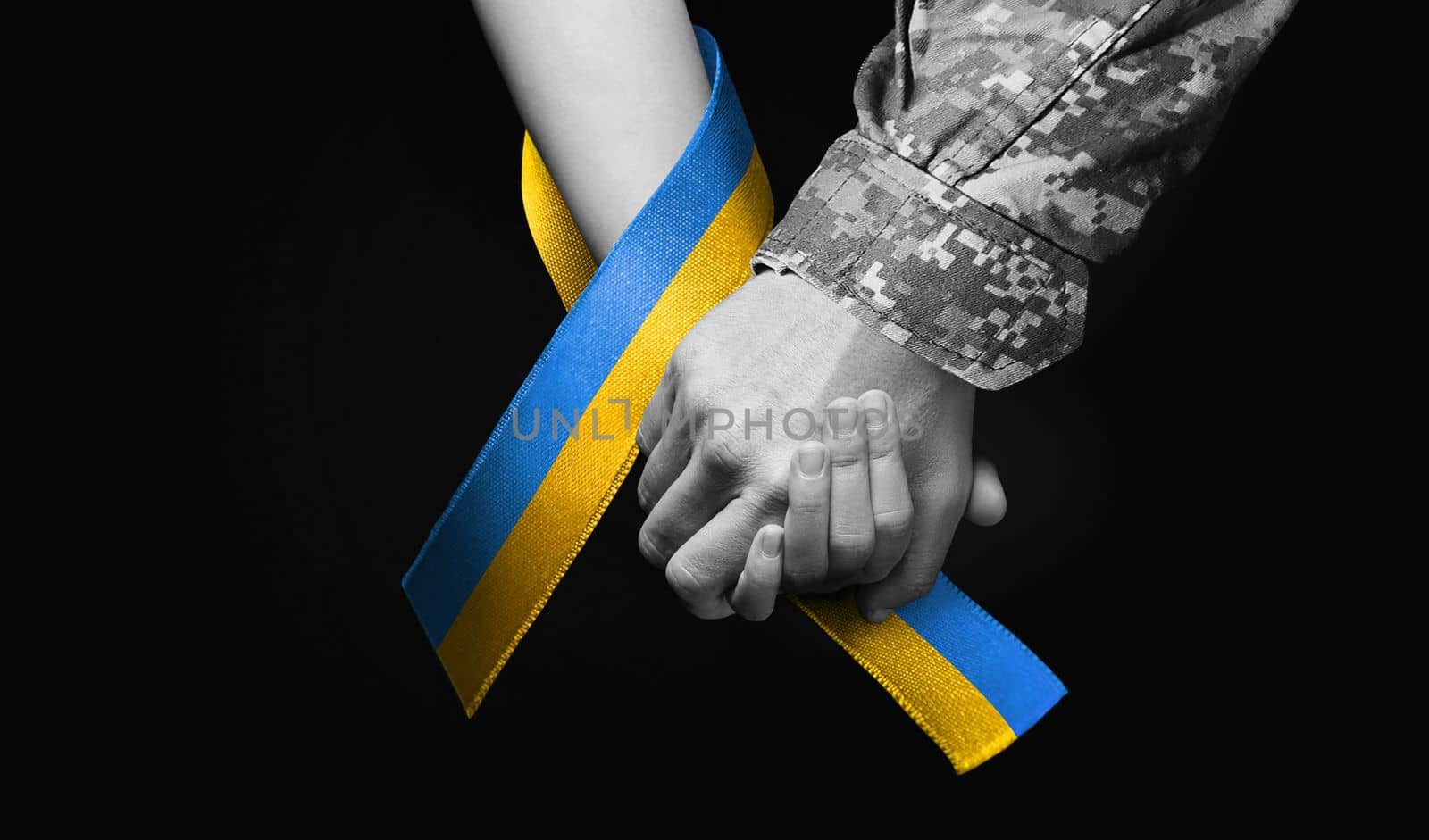hand of military man holds tightly hand of child with blue yellow ribbon around, I will not leave you in trouble black and white color. concept needs help and support, truth will win