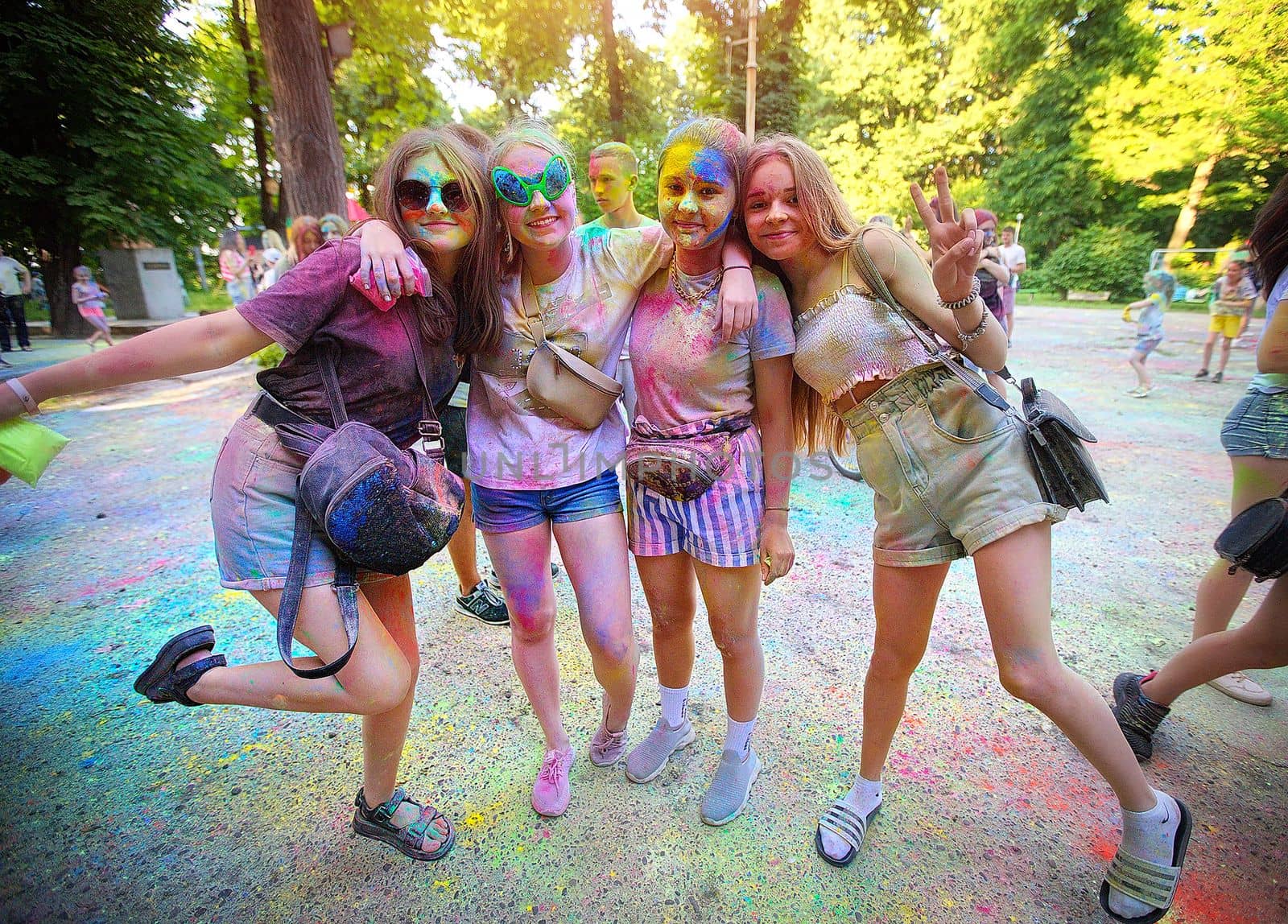 Young people, teenagers and adults celebrate the Holi event in Ukraine in Chernivtsi on March 8 in 2022. They have fun and throw paint at each other. High quality photo