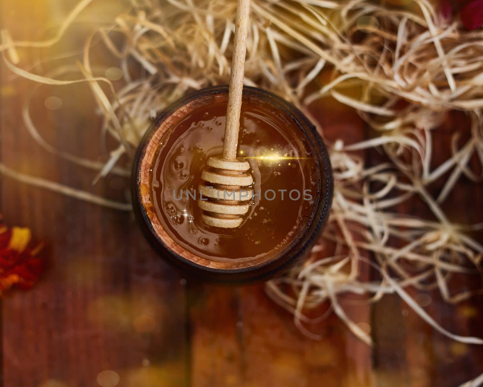 a jar of sweet honey in a bucket on a wooden table in the garden with flowers for breakfast delicious food. High quality photo