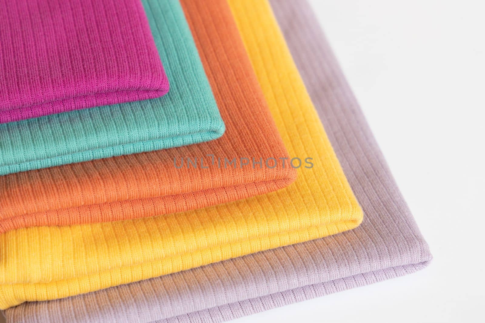 Stack folded colorful baby cotton clothing on white background isolation. Copy space. For advertising, commercial,mock up. by Ri6ka
