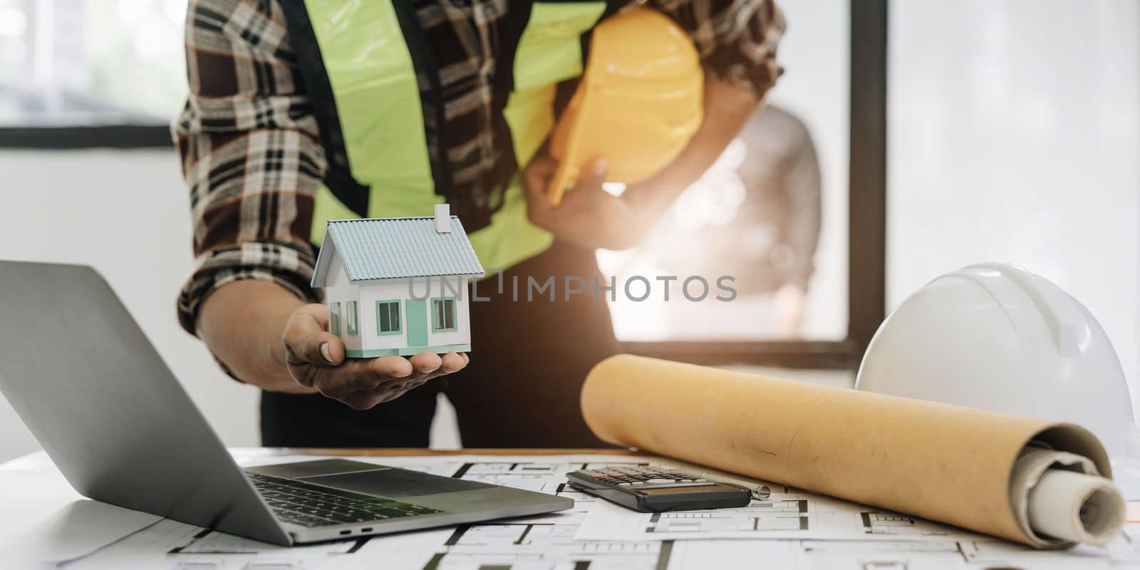 Close up of civil male engineer asian working on blueprint architectural project at construction site at desk in office