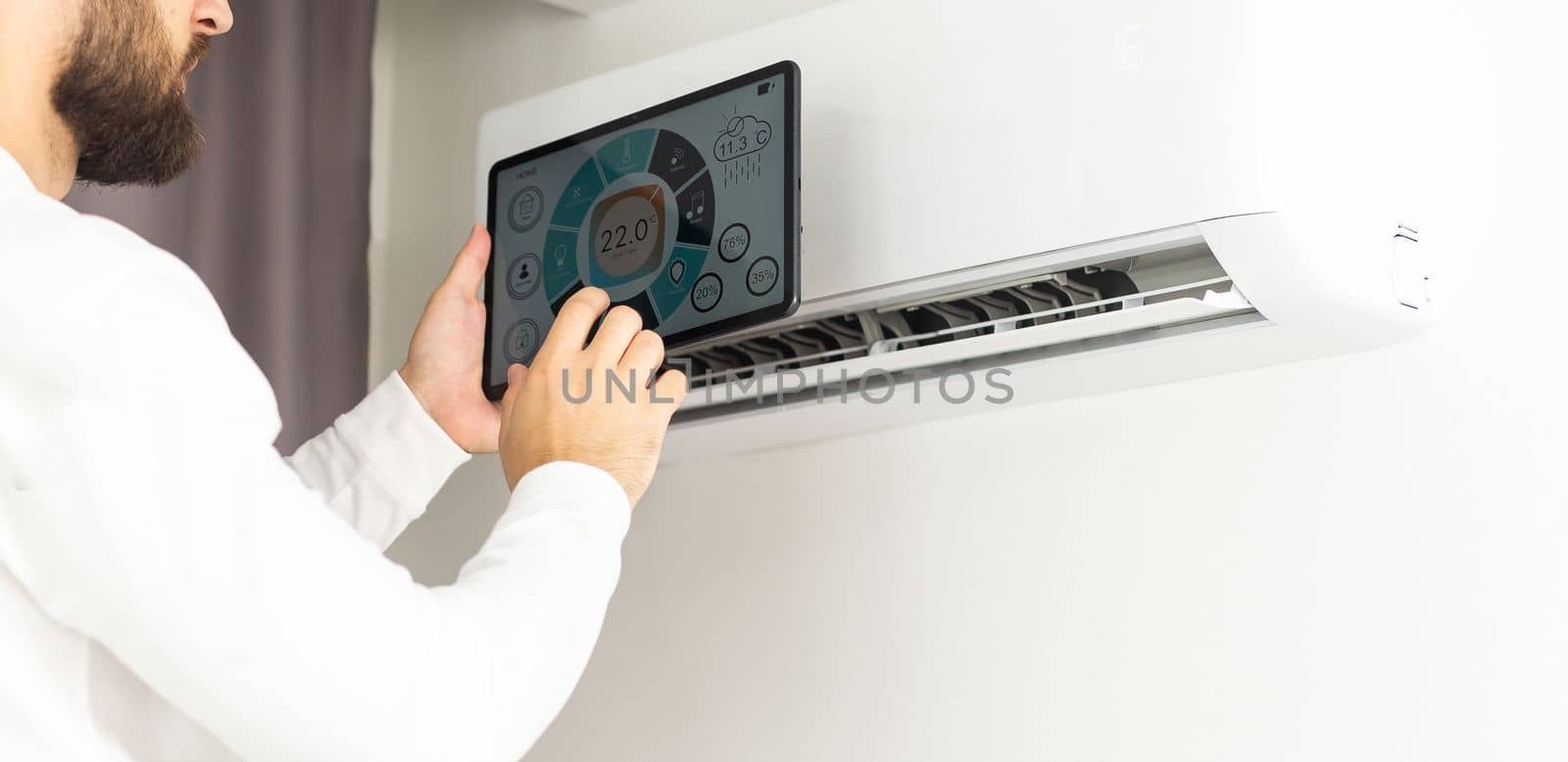 Male technician repairing air conditioner indoors