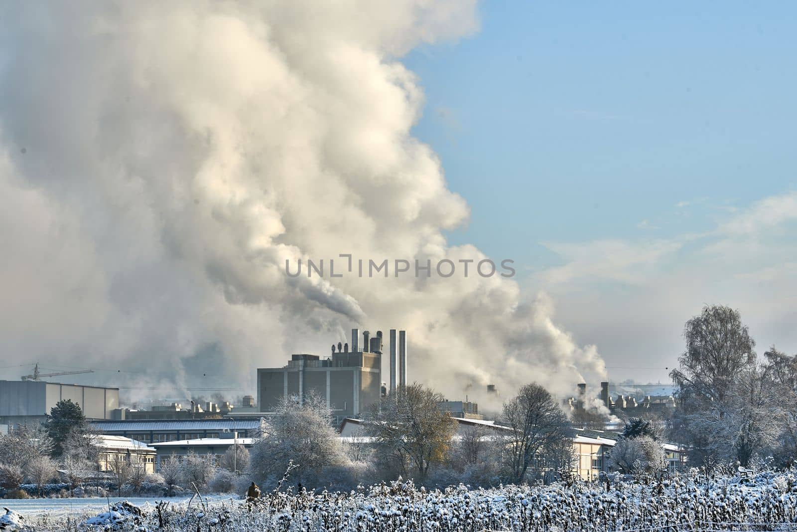 Environmental problem of pollution of environment and air in cities. Smoking industrial zone factory chimneys. View of large plant with Smoking pipes Smoke from the paper industry, which is running every day of the year. Photo taken December 2022 Air pollution in the city. Smoke from the chimney on blue sky background. by Costin