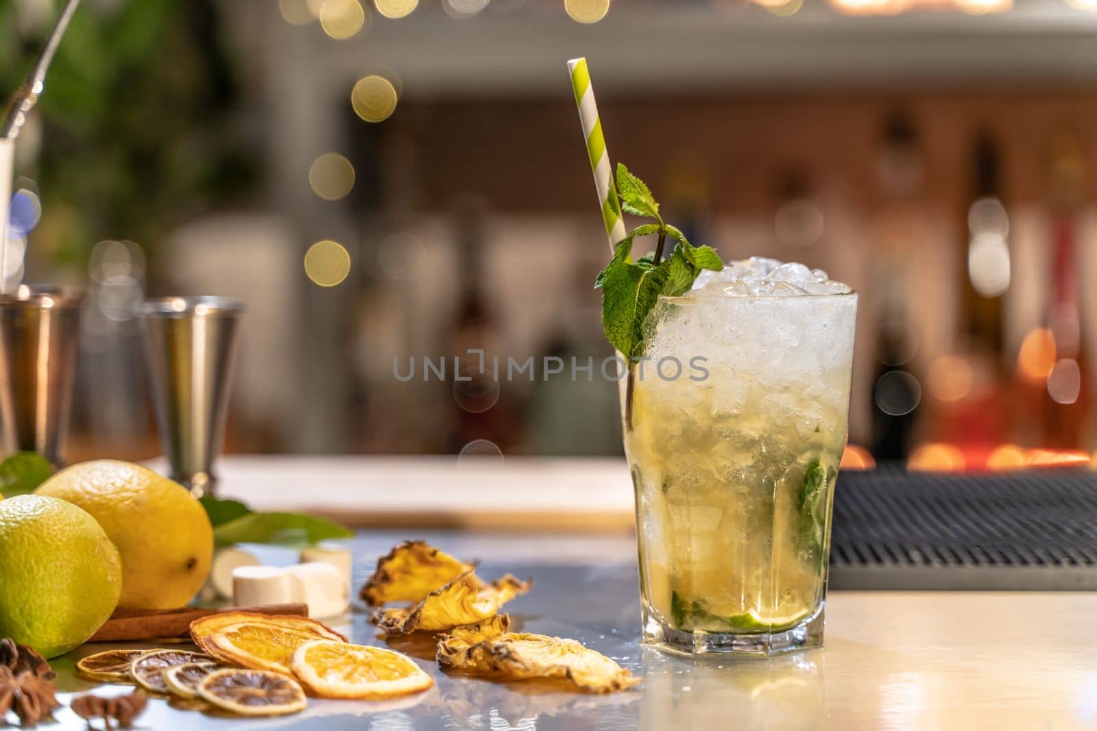 Mojito cocktail on bar counter with lemons, limes and species with copy space for text. High quality photo