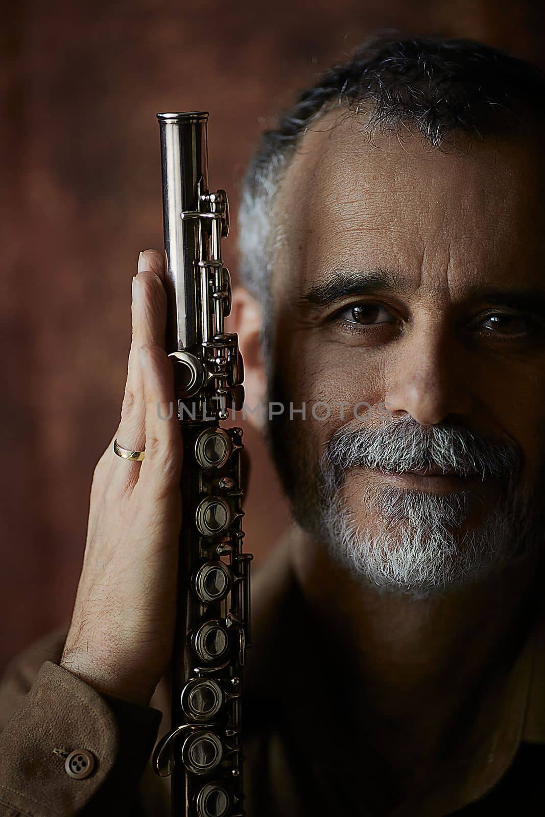 portrait of a musician whose hands hold a flute - an ancient musical wooden instrument, popular in classical brass marching jazz folk music, loved by children and adults, amateurs and professionals. High quality photo