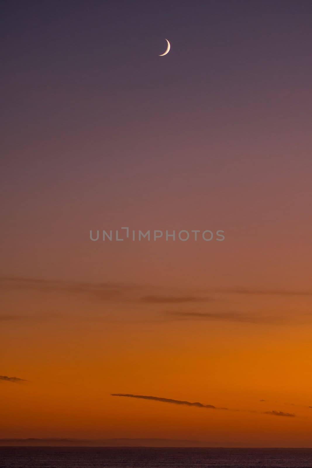 Sunrise over the Indian Ocean at Struisbaai with moon visible by dpreezg