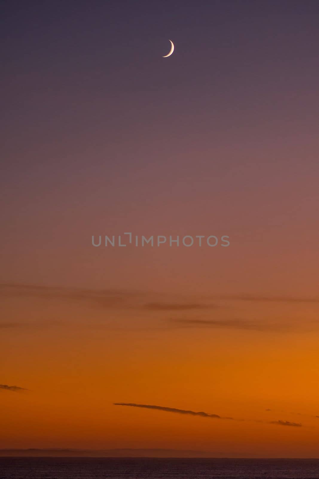 Sunrise over the Indian Ocean at Struisbaai, in the Western Cape Province. The moon is visible