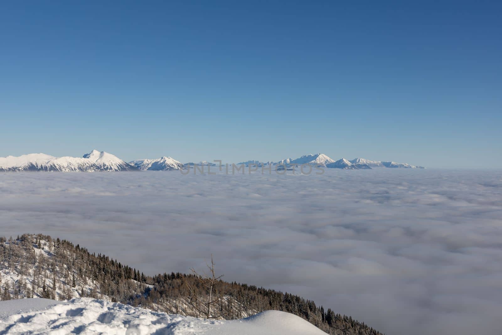 Winter mountains covered with snow landscape over clouds. High quality photo