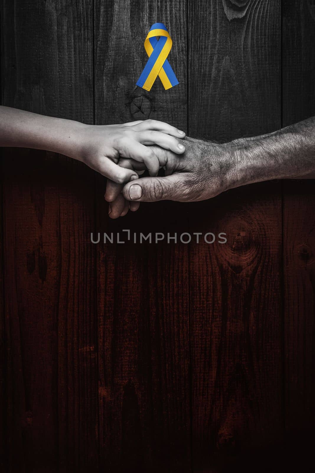 male hands hold childrens on dark wooden background with red bottom. concept needs help and support, truth will win