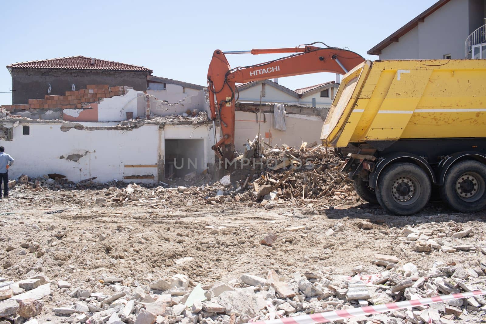 Urla, Turkey - may 13, 2020 : excavator loading debris of a destroyed building in truck. by senkaya