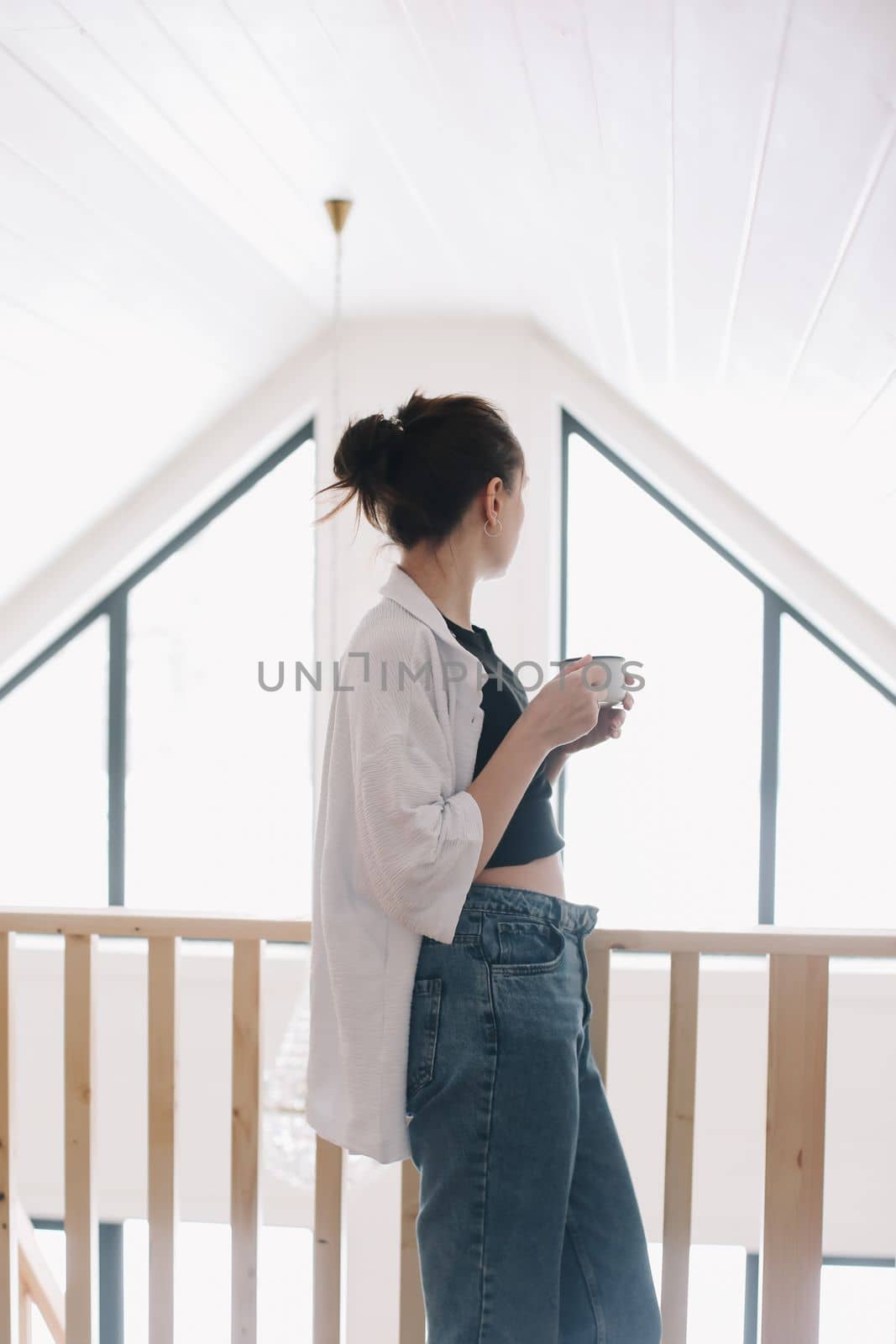 young woman drink coffee and enjoy a wonderful morning in the light room at home.