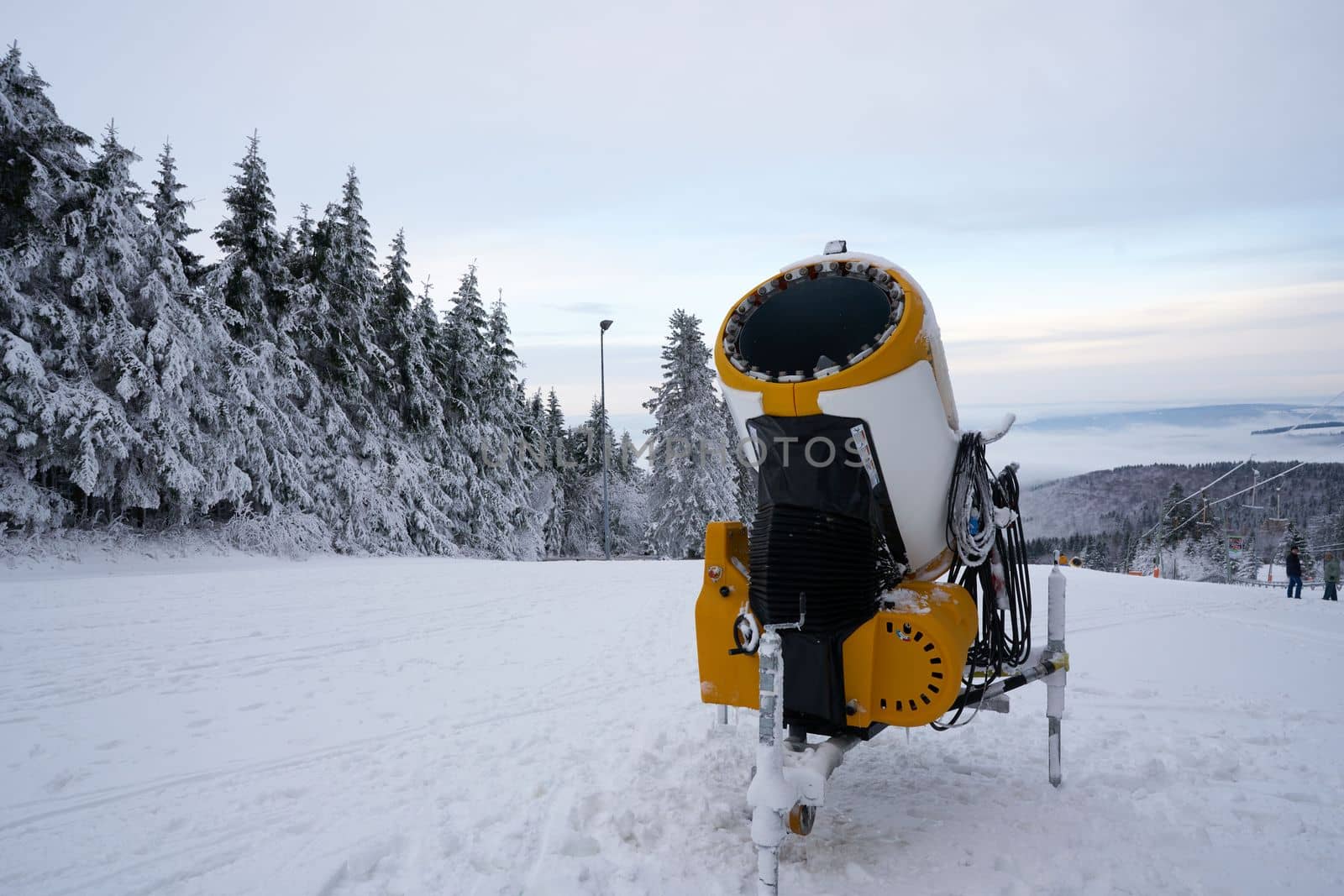 Yellow artificial snow cannon on Wasserkuppe ski resort in Rhoen Hesse Germany, on snowy mountain after fresh snow fall in 2022 december by Costin