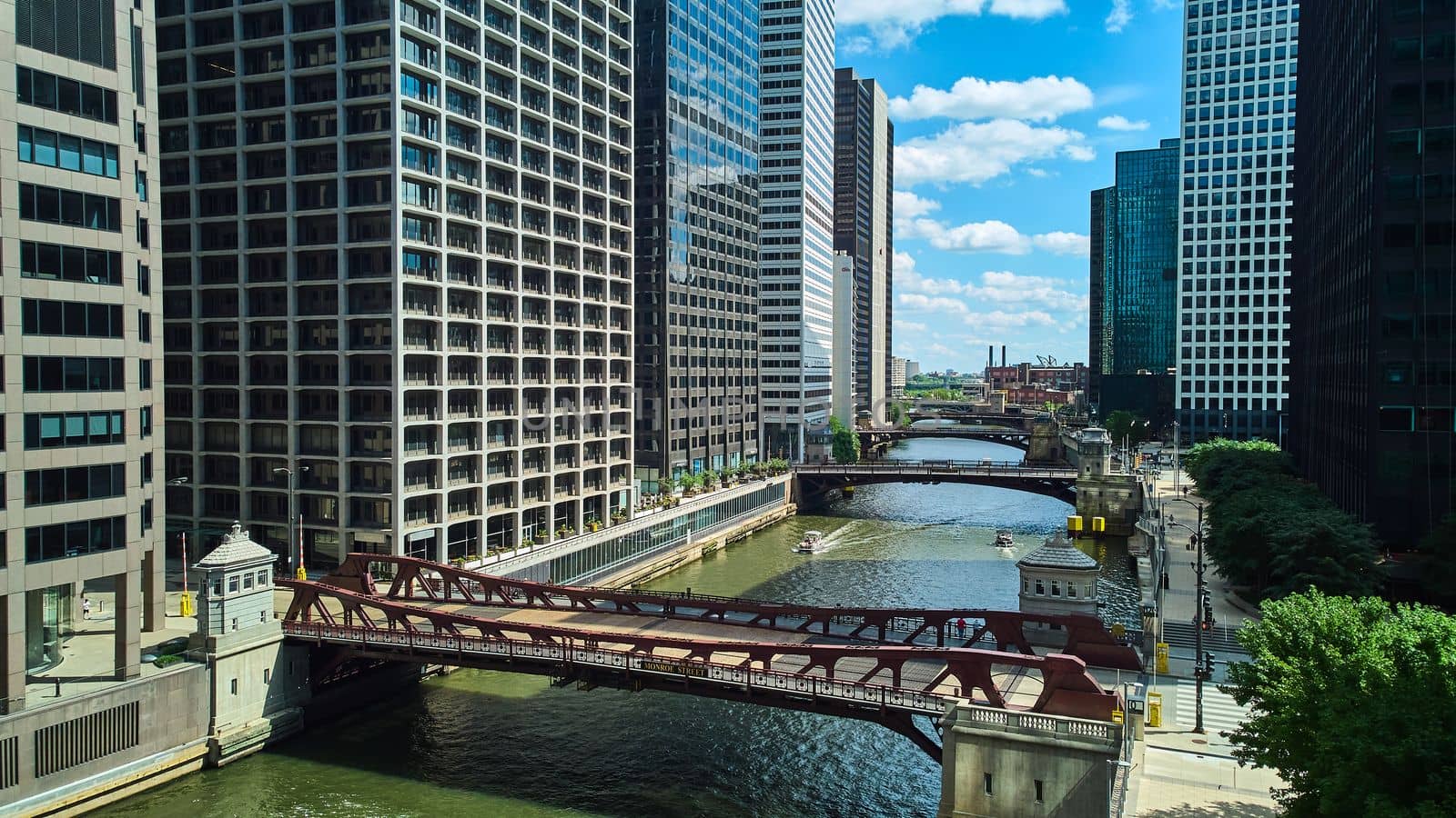 Image of View down row of bridges through the Chicago ship canal surrounded by skyscrapers