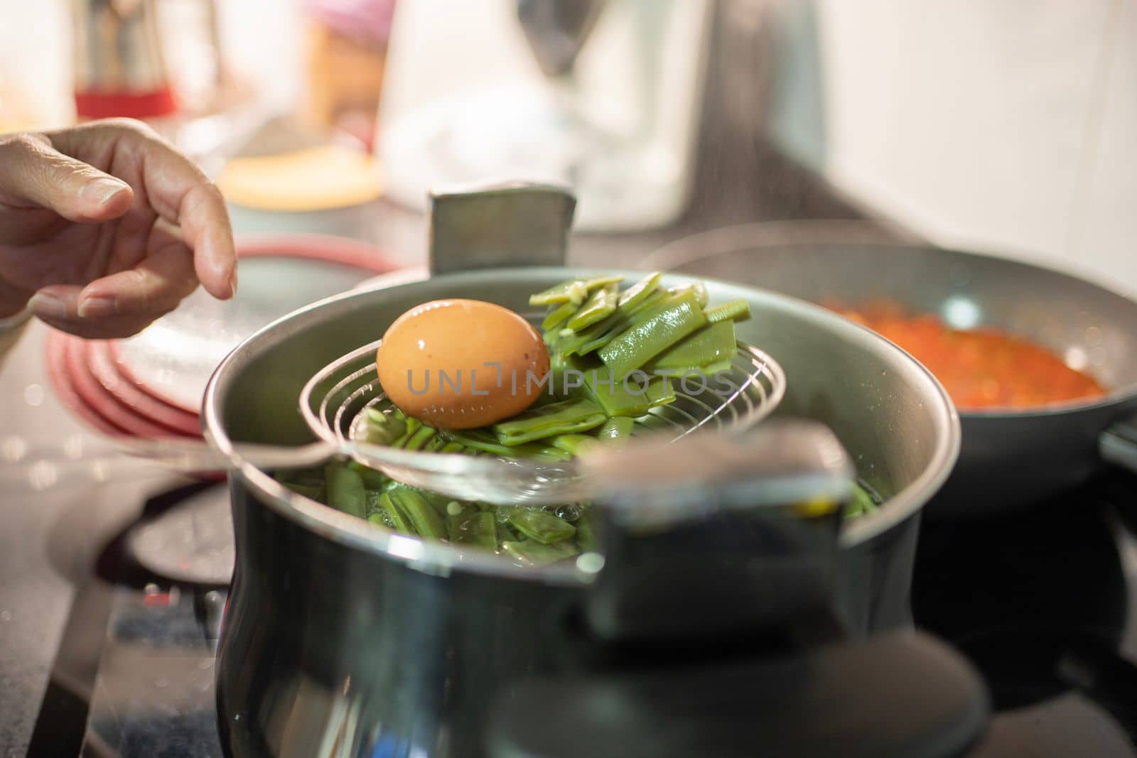 old woman finger pointing to cooked boiled eggs and green beans ready to eat. Cheap , healthy and economic food concept.