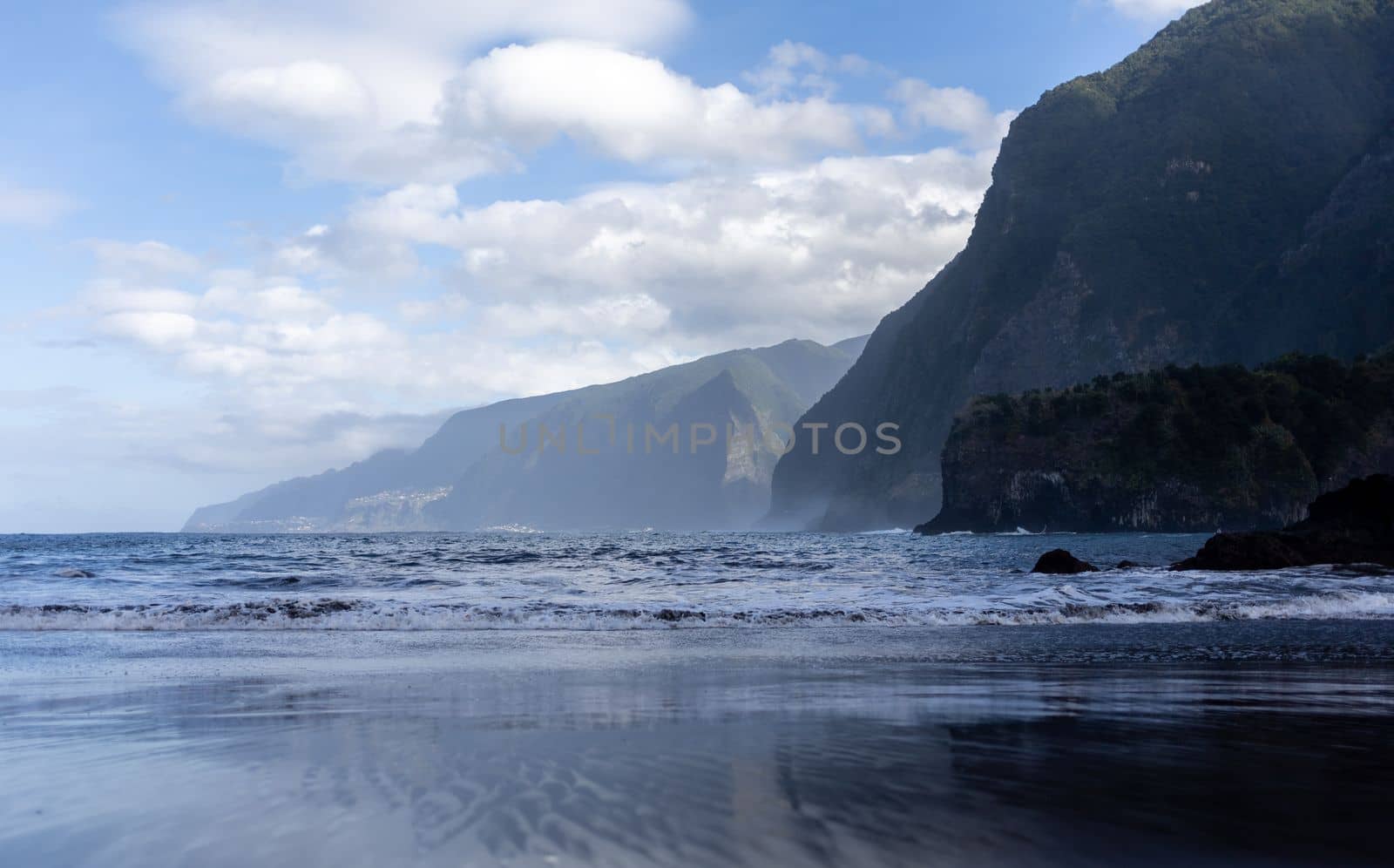 black sand beach of Madeira view on mountains by Chechotkin