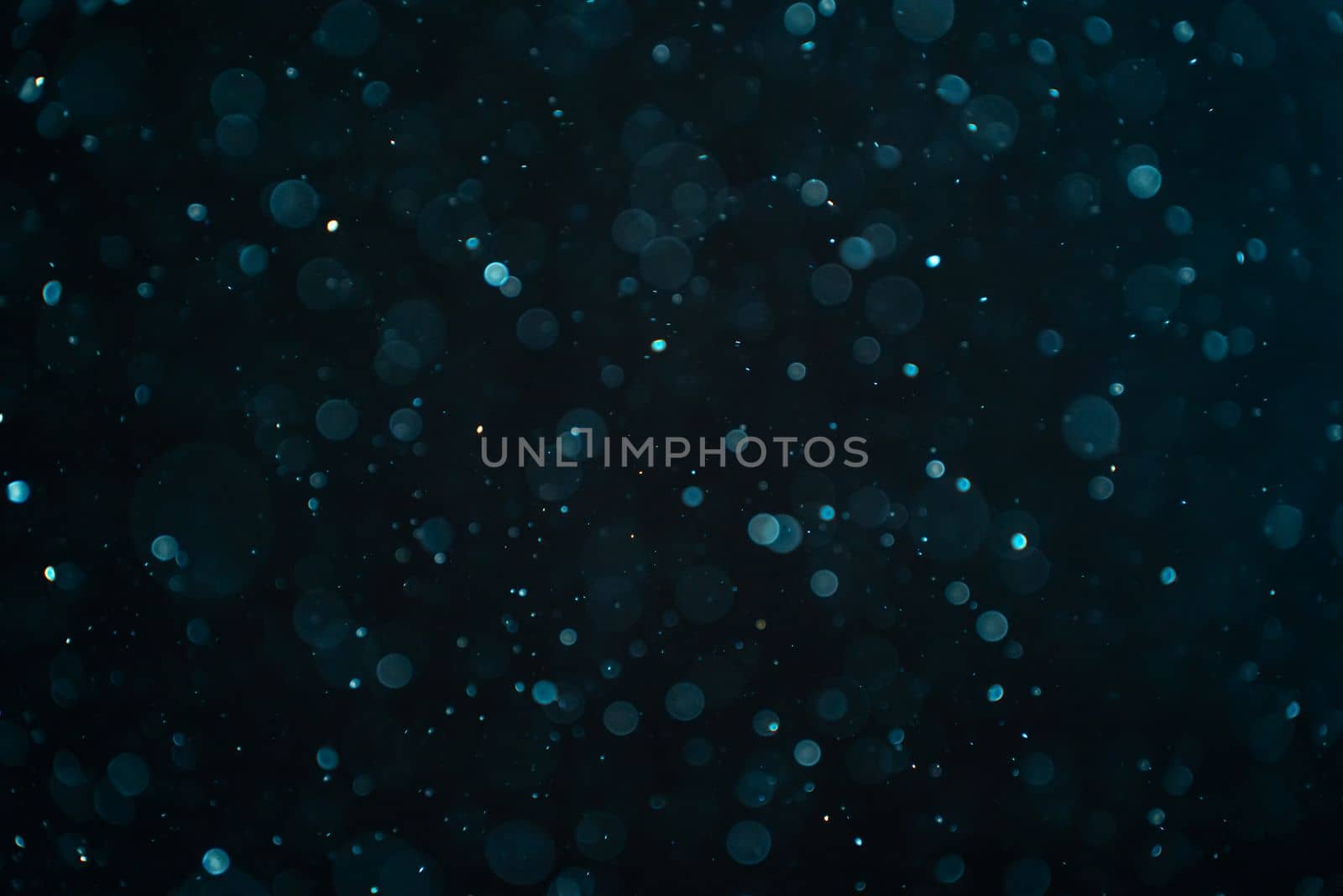 Abstract real dust particles on black background. Glittering sparkling bokeh overlay design with copy space for text. High quality photo