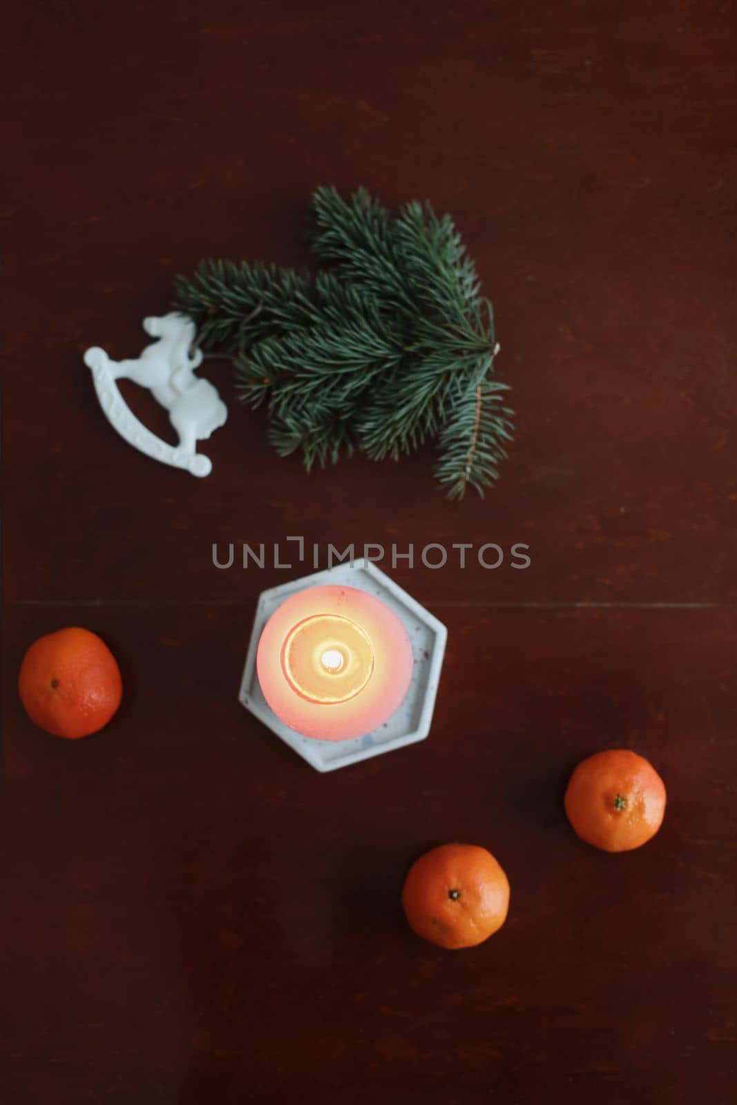 Christmas Toy horse, candle, tangerines and pine cone. Winter holiday items for home decor. Flat lay stock photography.