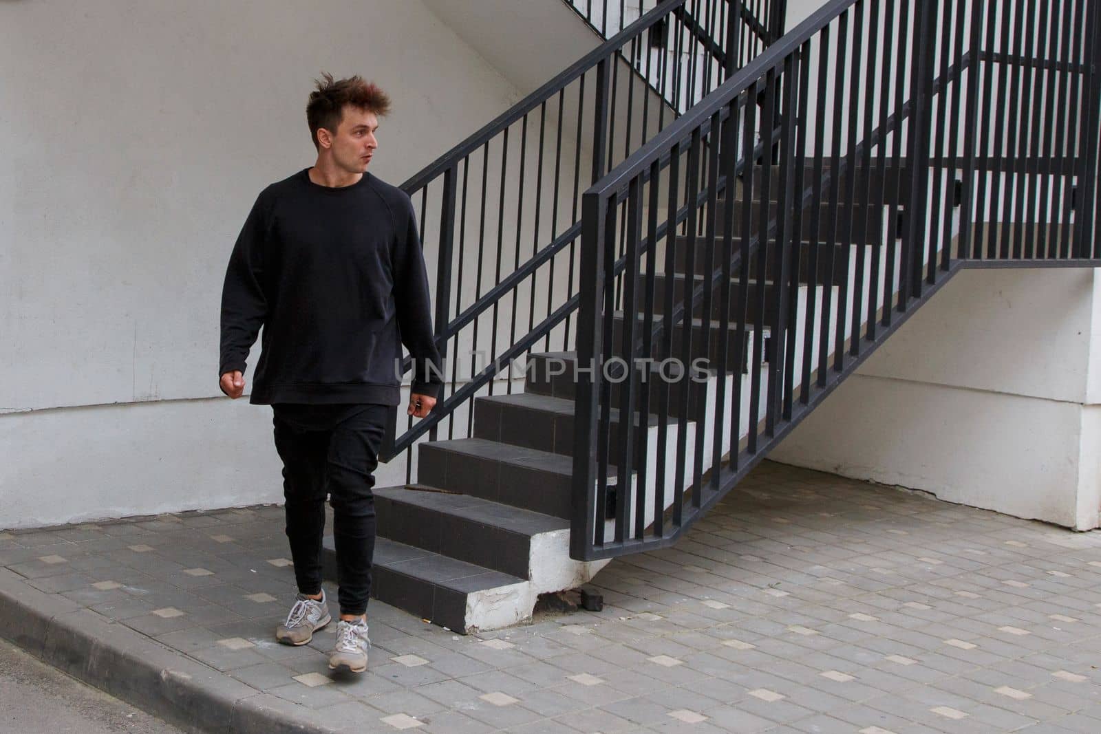 A man walks down a concrete staircase.