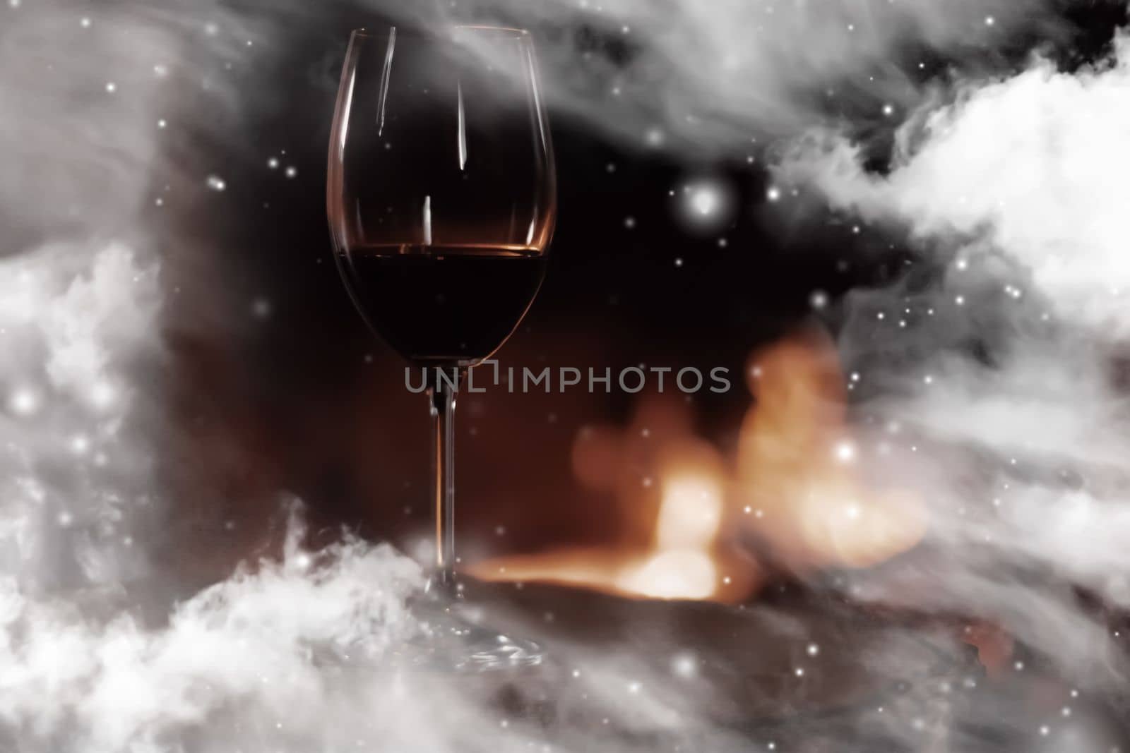 Winter atmosphere and Christmas holiday time, glass of wine in front of fireplace covered with snowy effect on window glass, holidays backgrounds