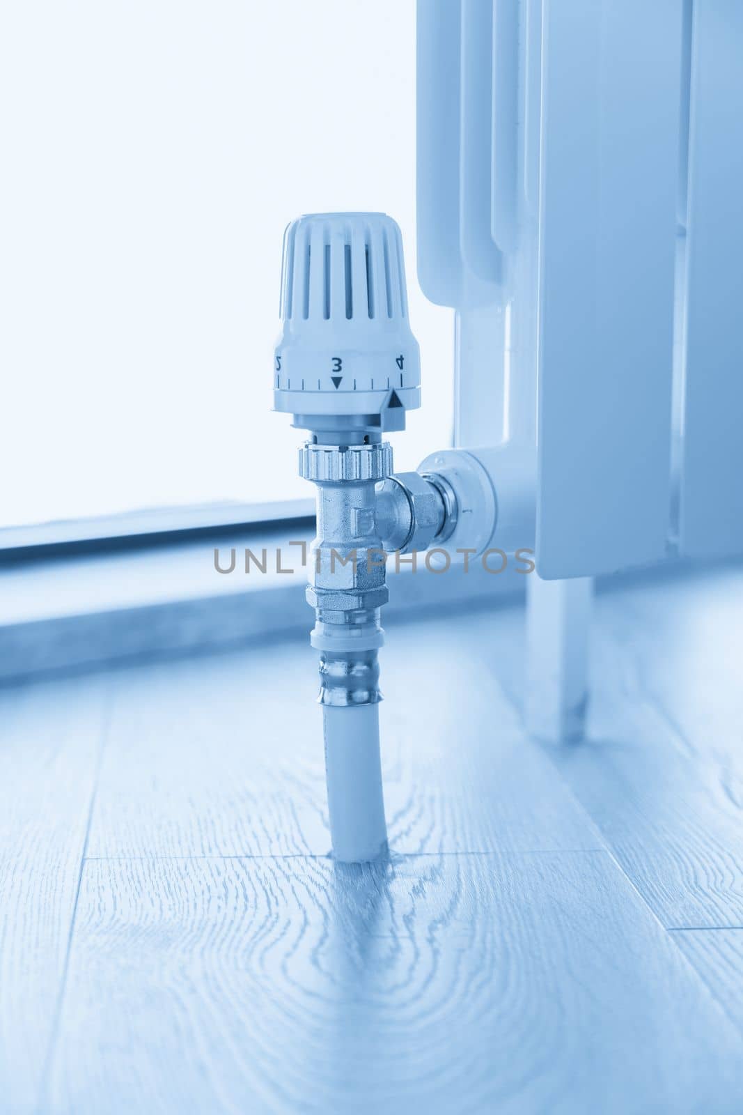 thermostat valve on white radiator close up by Mariakray