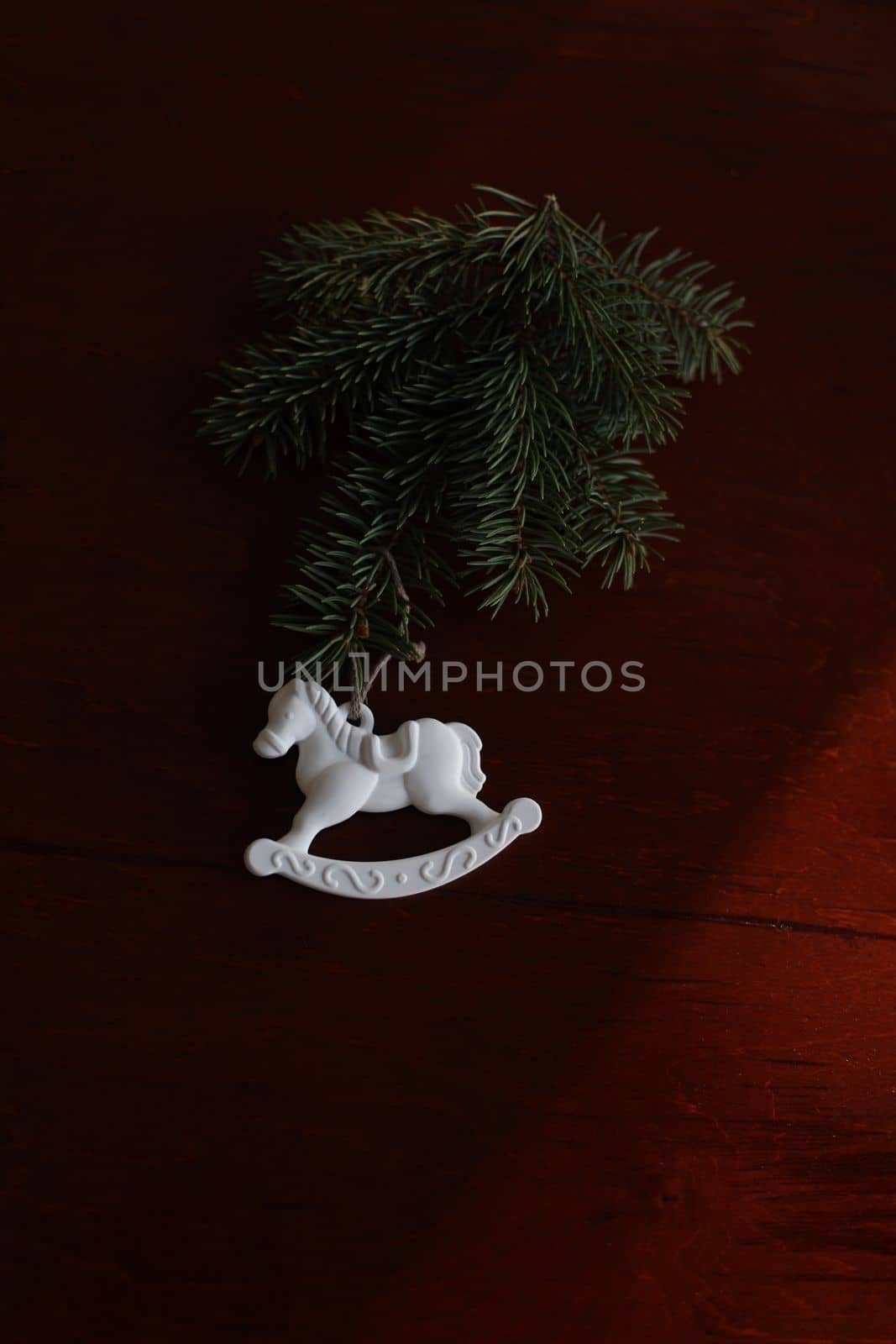 Christmas tree, toy horse, gift box, pine cone on a wooden table background top view. New Year home decoration. Festive design