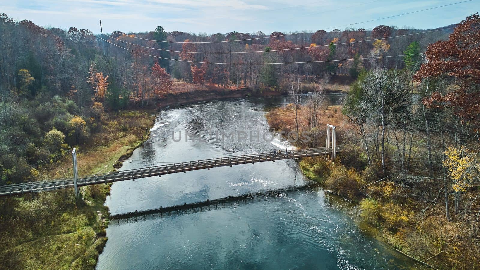 Image of Late fall vibes aerial at suspension bridge over river in Michigan 