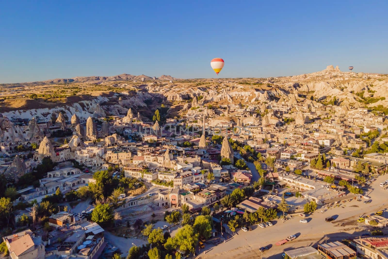 Colorful hot air balloons flying over at fairy chimneys valley in Nevsehir, Goreme, Cappadocia Turkey. Spectacular panoramic drone view of the underground city and ballooning tourism. High quality by galitskaya