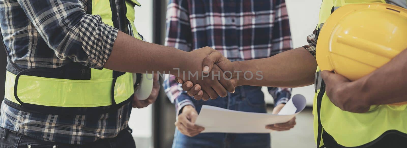 construction worker team hands shaking after consultation meeting to greeting start up plan new project contract in office center at construction site, teamwork, partnership and contractor concept..