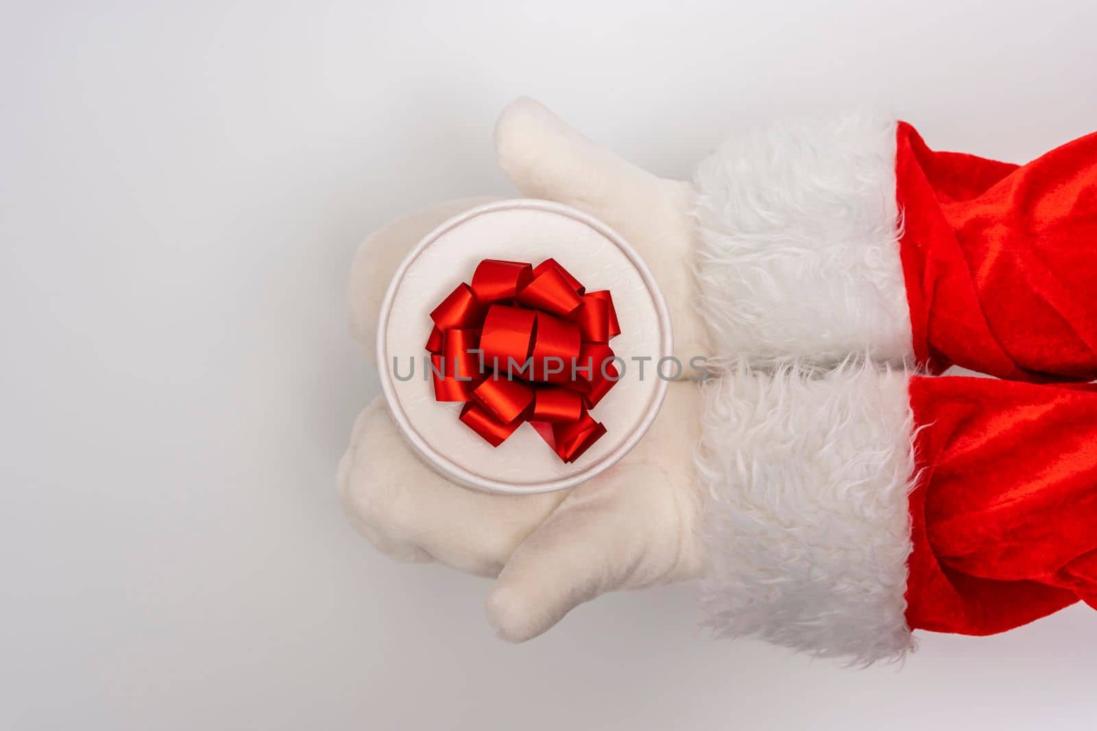 Santa's hands are holding a gift for Christmas. white background with space to copy. Christmas time