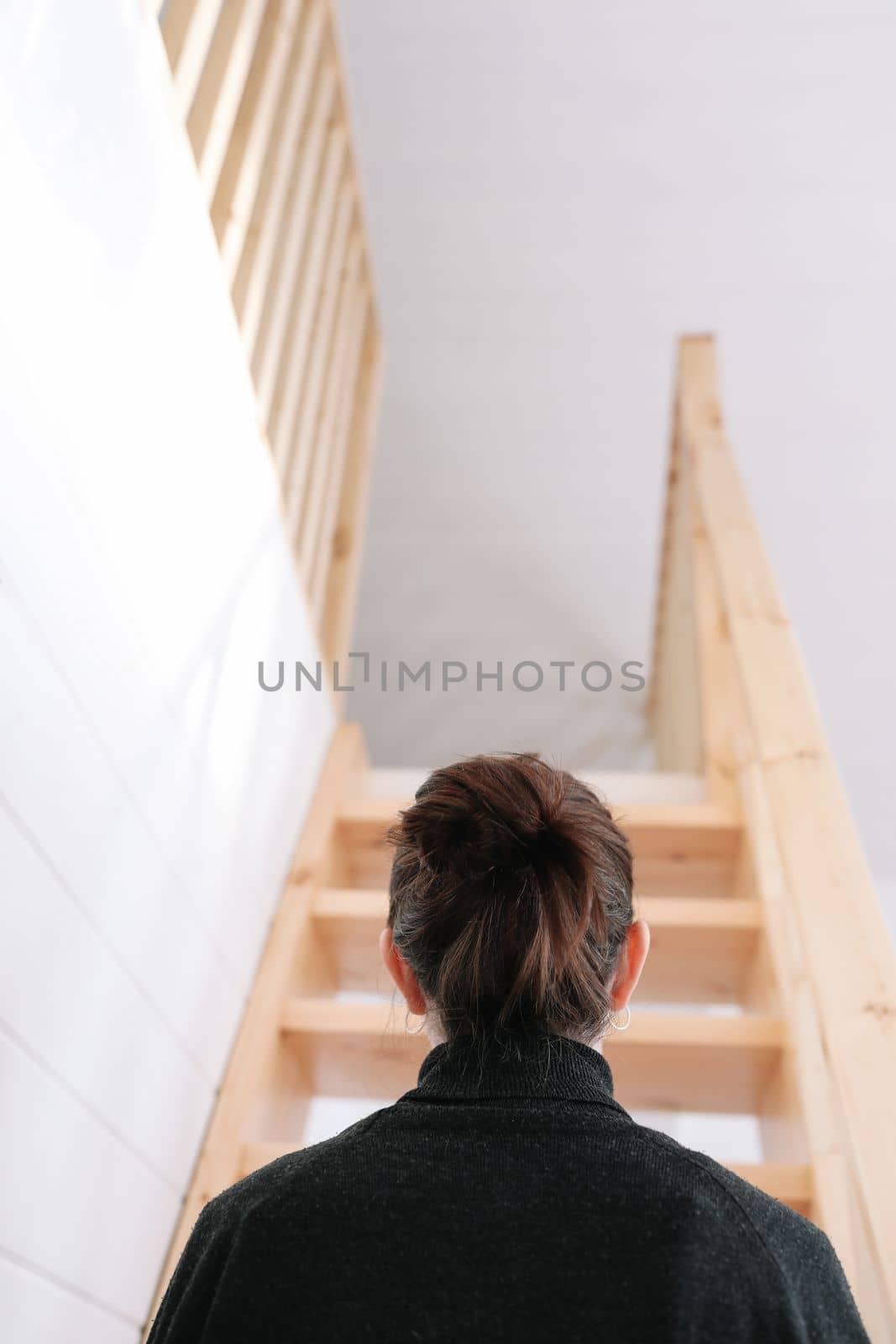 Young woman simple hairstyle back view by wooden stairs at home. Depression, loneliness and quarantine concept. Mental health, Self care, staying home. by paralisart