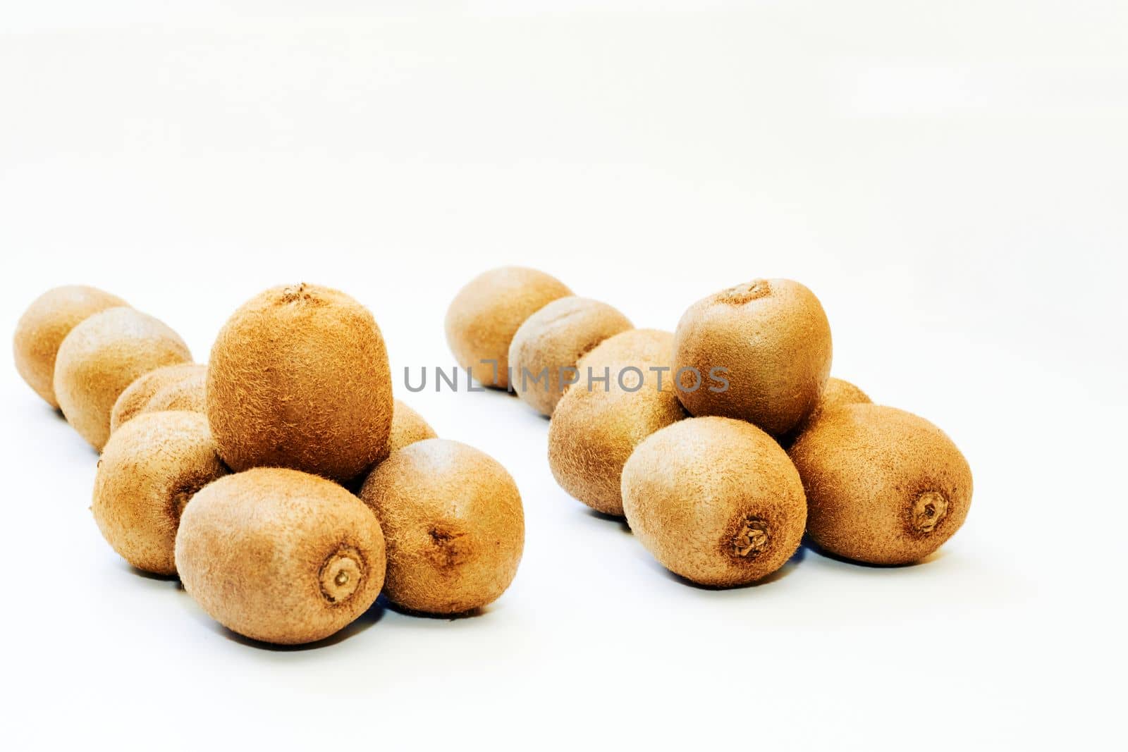 a flightless New Zealand bird with hairlike feathers, having a long down-curved bill with sensitive nostrils at the tip. Several ripe tasty kiwis isolated on white.