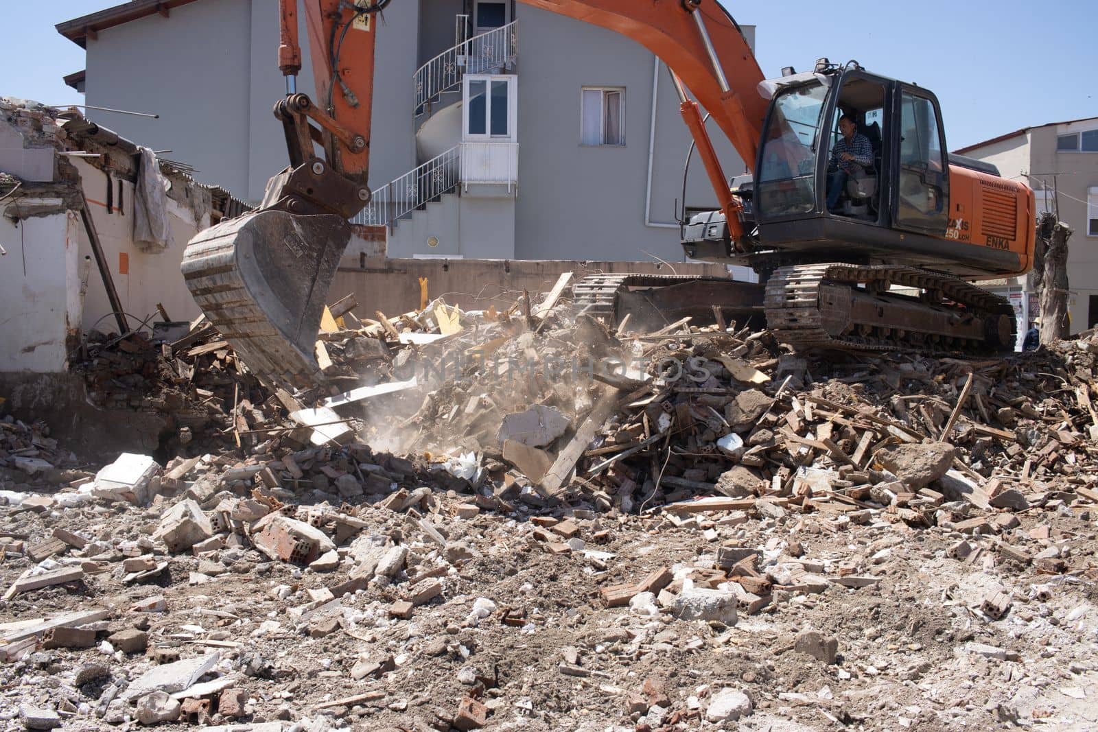 Urla, Turkey - may 13, 2020 : excavator loading debris of a destroyed building in truck. by senkaya
