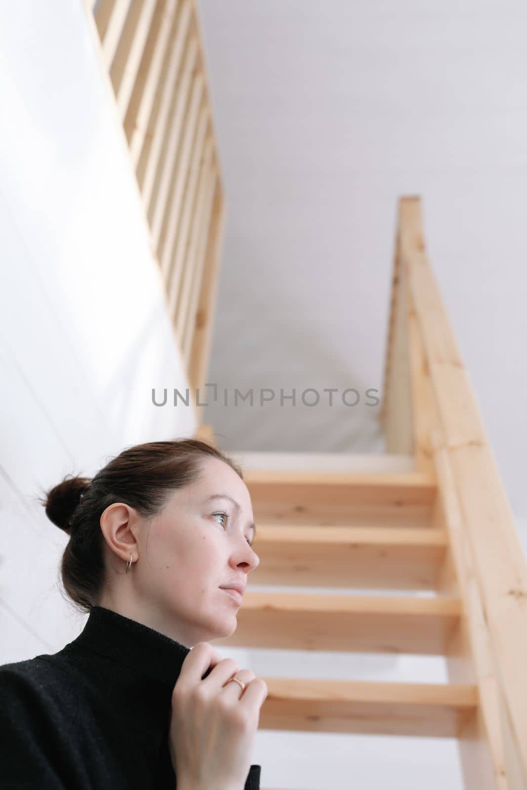 Young woman simple hairstyle against wooden stairs. Depression, loneliness and quarantine concept. Mental health, Self care, staying home