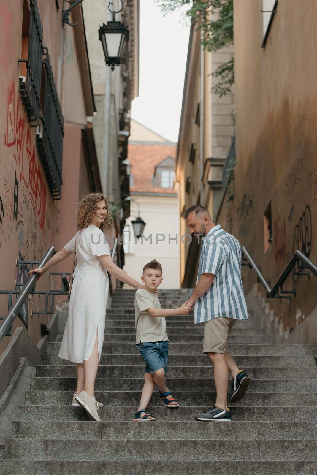 Family is climbing stairs in an old European town. by RomanJRoyce