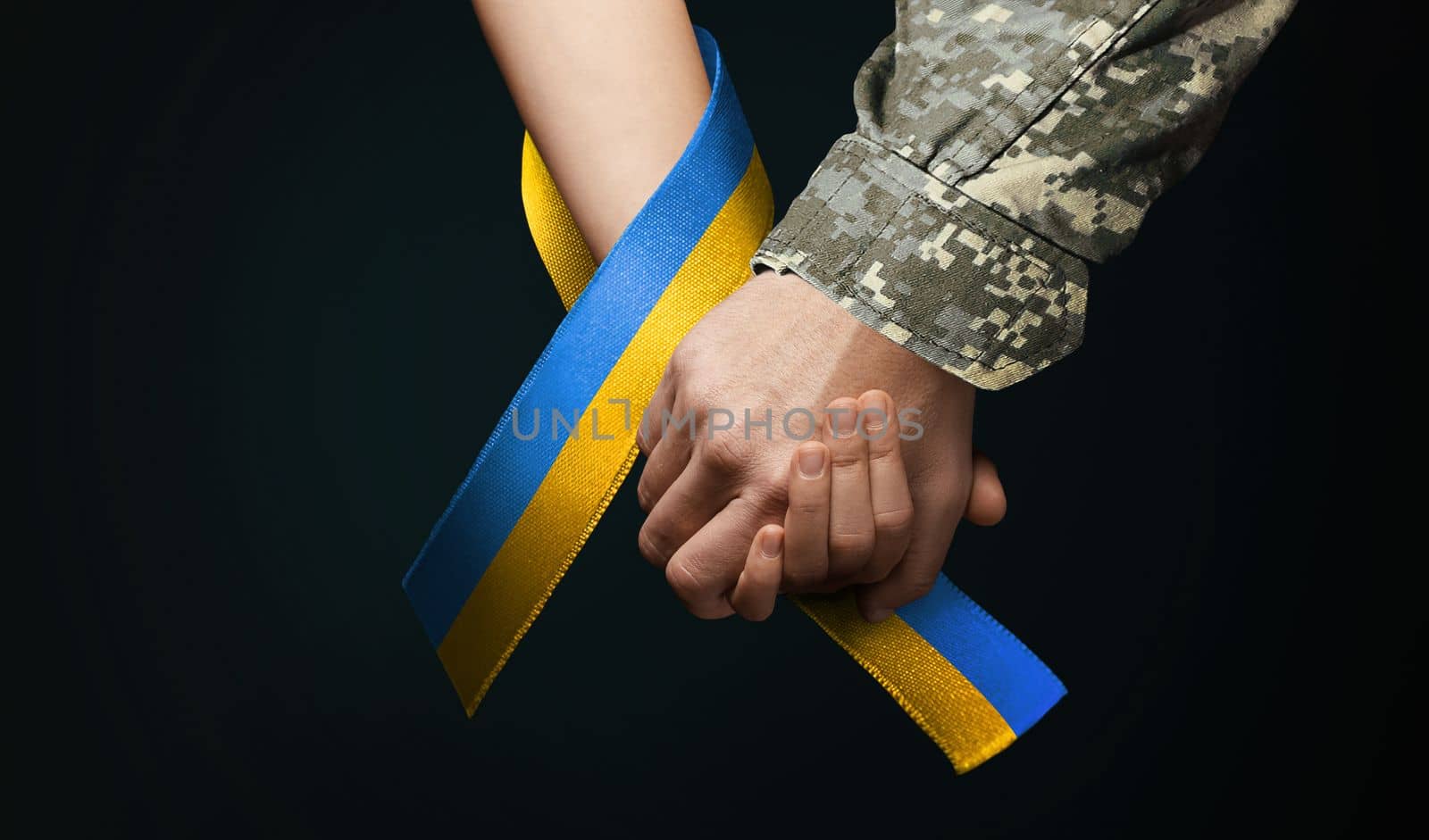 military man holds tightly hand of child by alexxndr