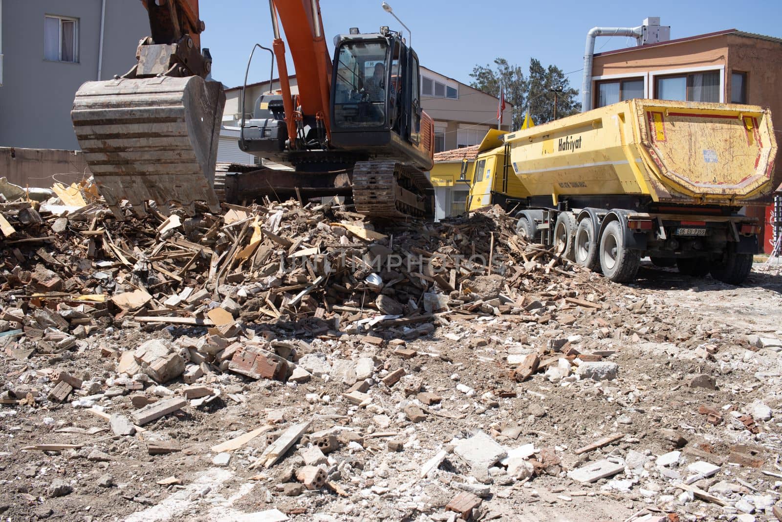 Urla, Turkey - may 13, 2020 excavator loading debris of a destroyed building in truck.