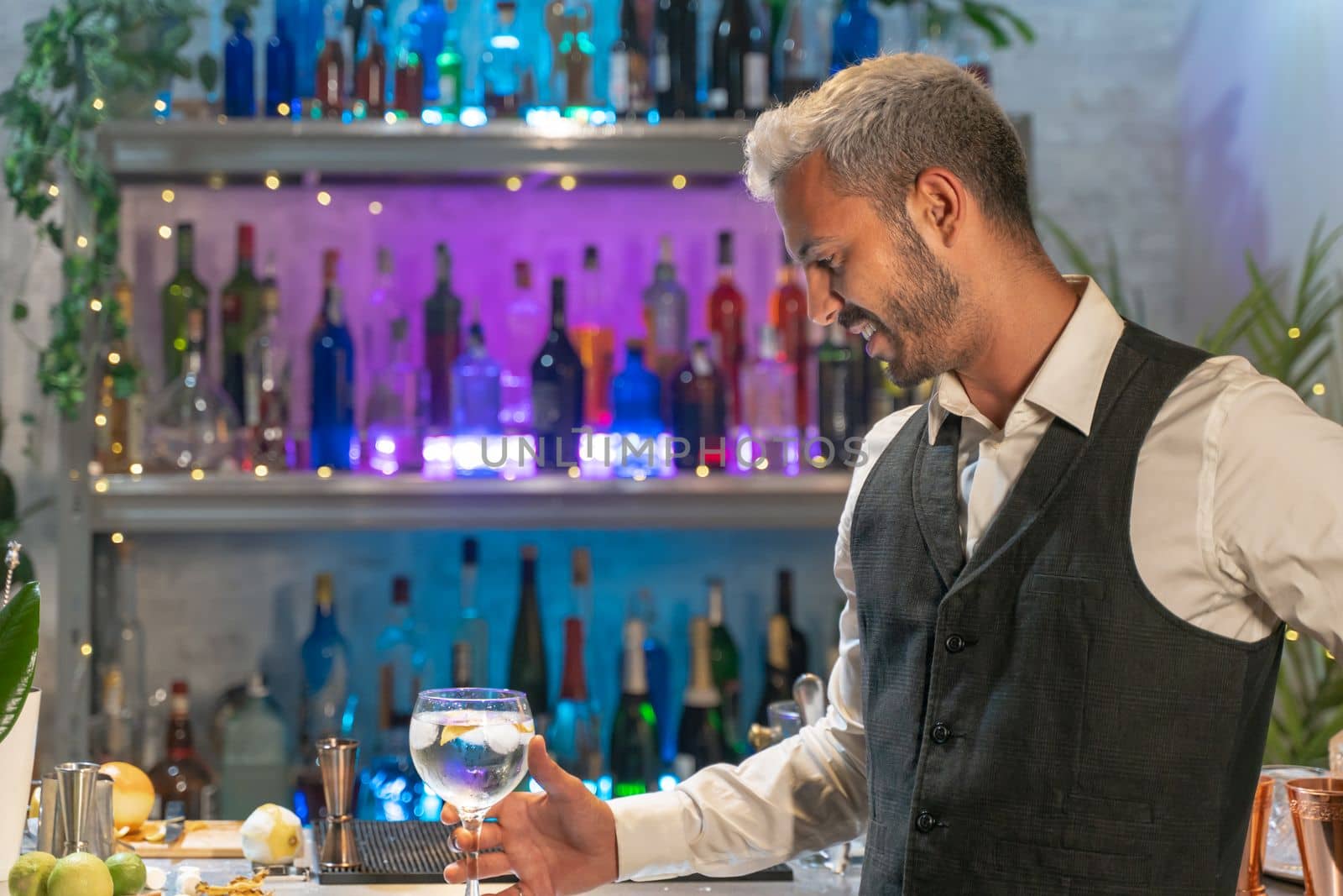 Professional barman looking cocktail in nightclub. Night life concept. High quality photo