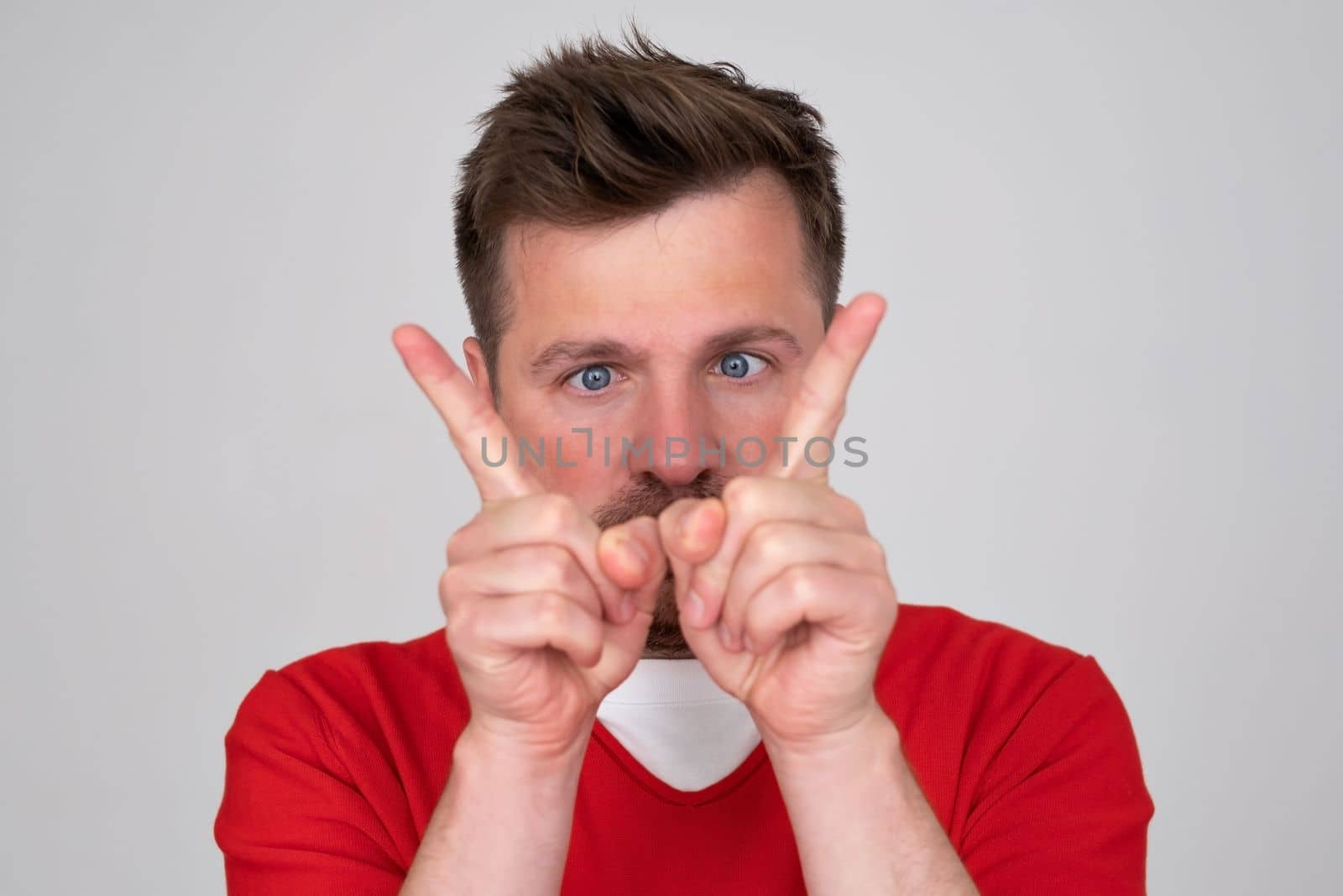 Caucasian man choosing between two options concept. He points to different sides by his fingers. Studio shoot. 